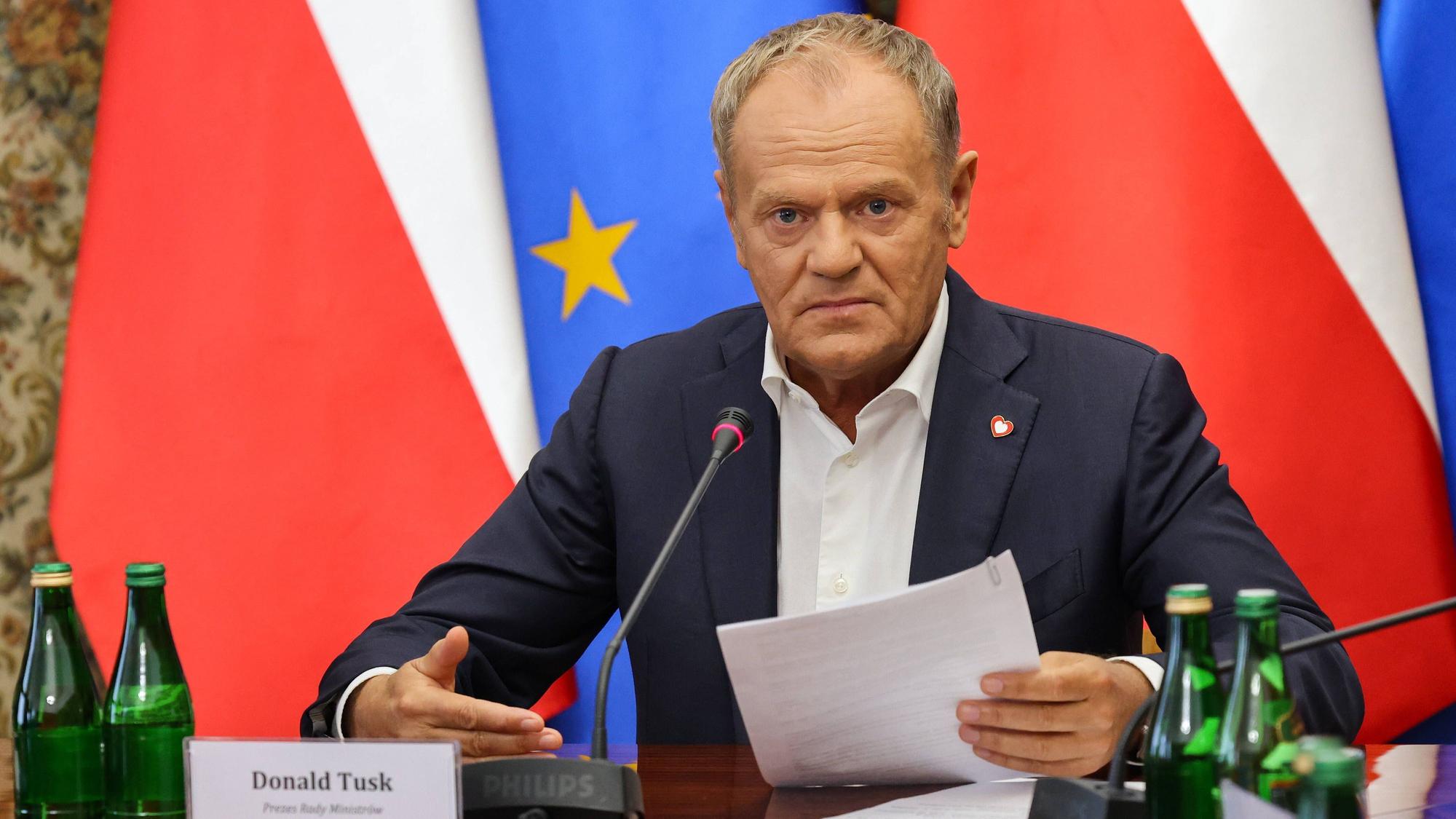 Ministerpräsident Donald Tusk hält ein Dokument während einer Sitzung im Amt des Ministerpräsidenten in Warschau.