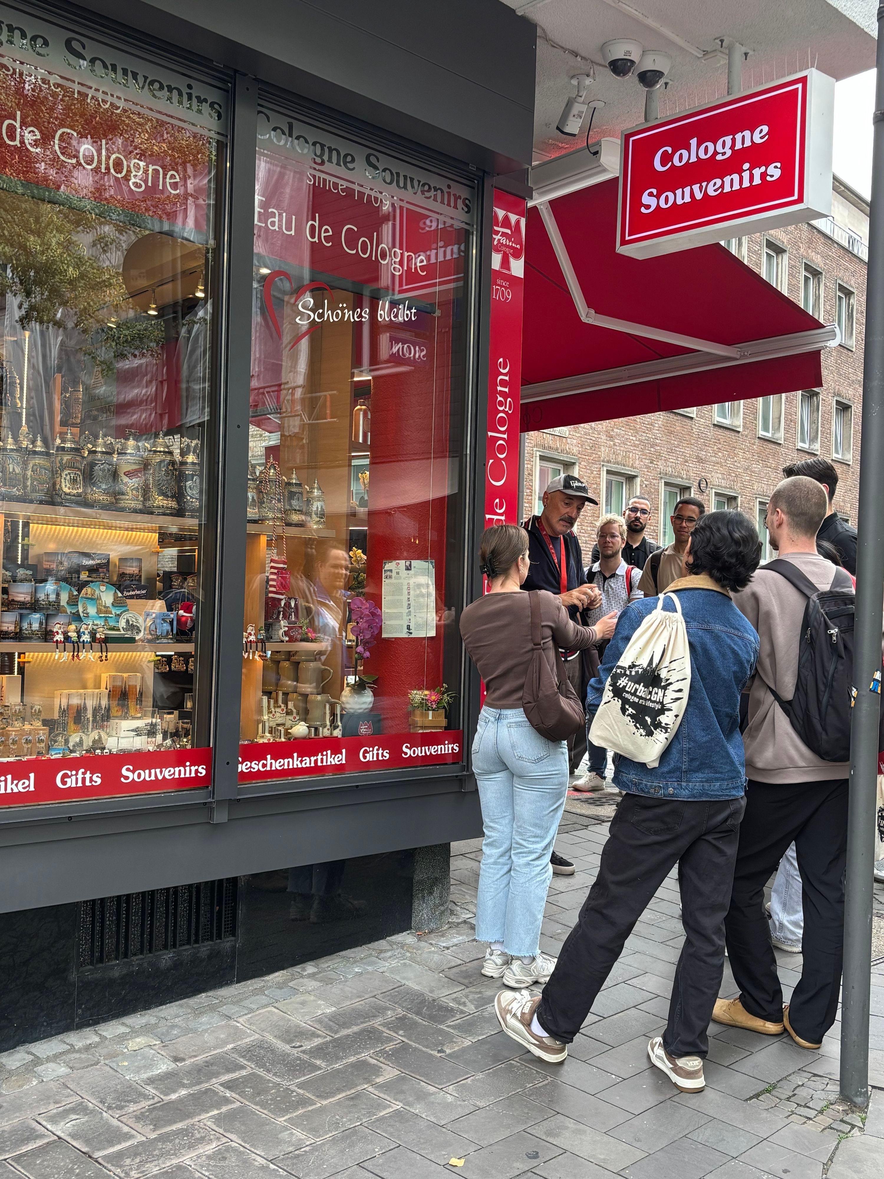 Eine Stadtführung hält vor dem Souvenirshop in der Kölner Altstadt.