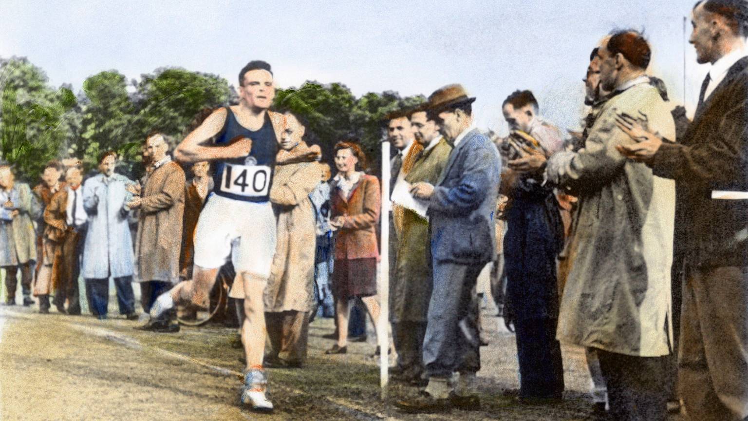 Alan Turing läuft an einer Reihe von Zuschauern vorbei..