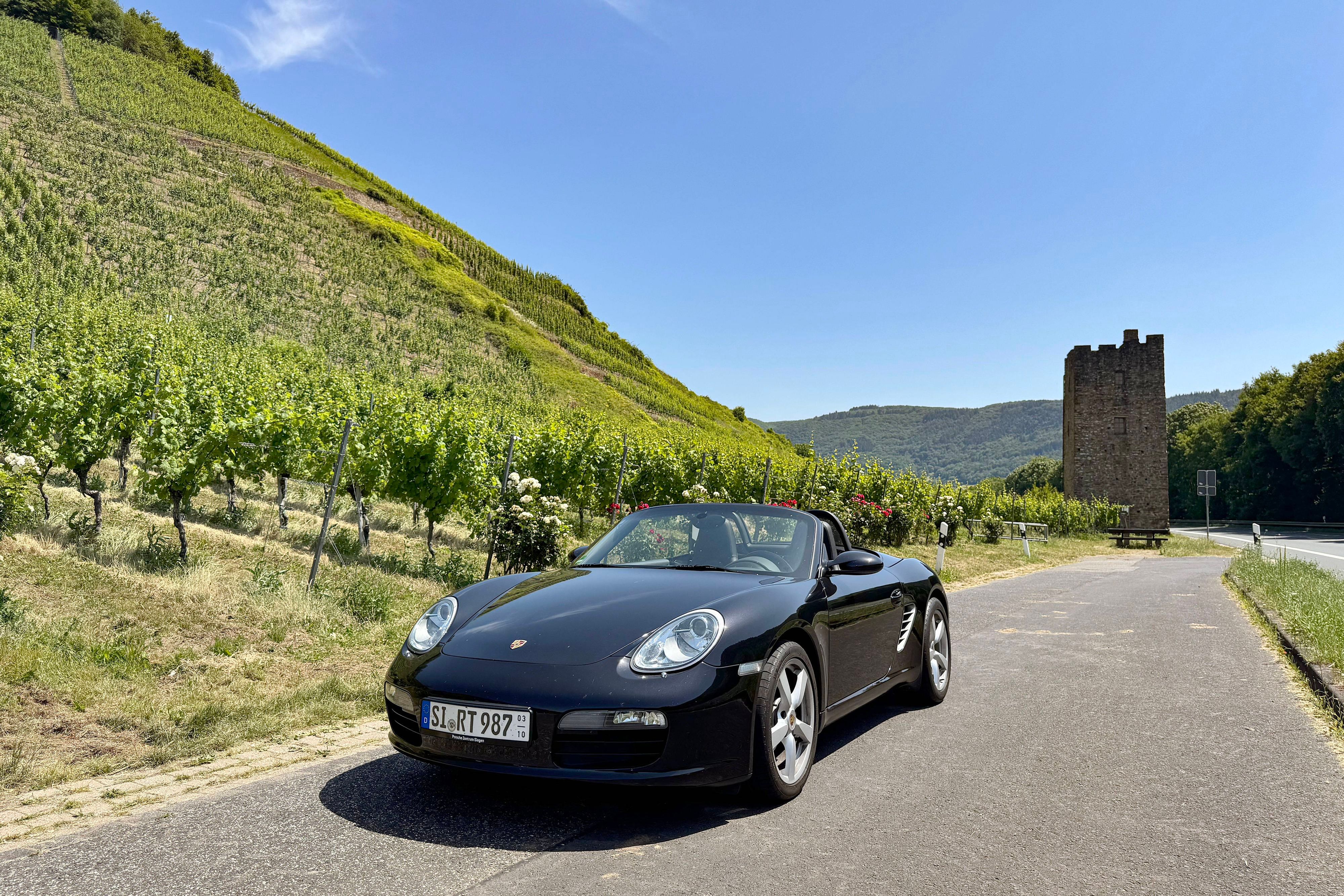 Cabrio-Ausfahrt zwischen Reben und Geschichte: Auf der Moselweinstraße bei Ediger-Eller säumen steile Weinberge und steinerne Zeugen vergangener Jahrhunderte das Asphaltband.