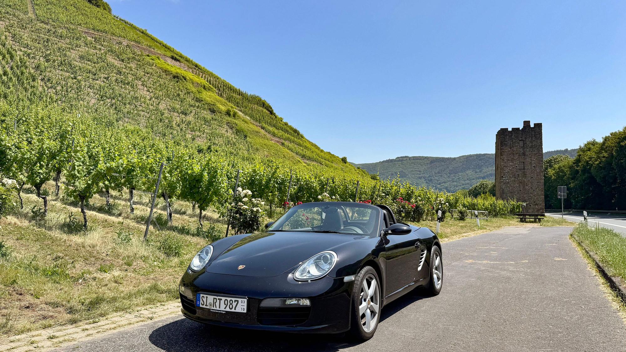 Cabrio-Ausfahrt zwischen Reben und Geschichte: Auf der Moselweinstraße bei Ediger-Eller säumen steile Weinberge und steinerne Zeugen vergangener Jahrhunderte das Asphaltband.