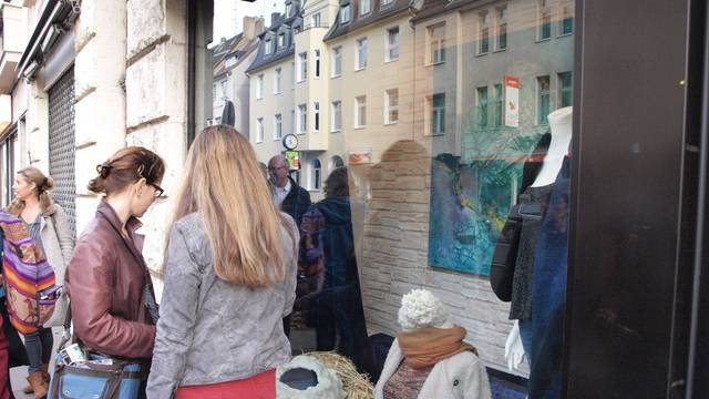 Zwei Frauen stehen vor einem Schaufenster und betrachten die Auslage.