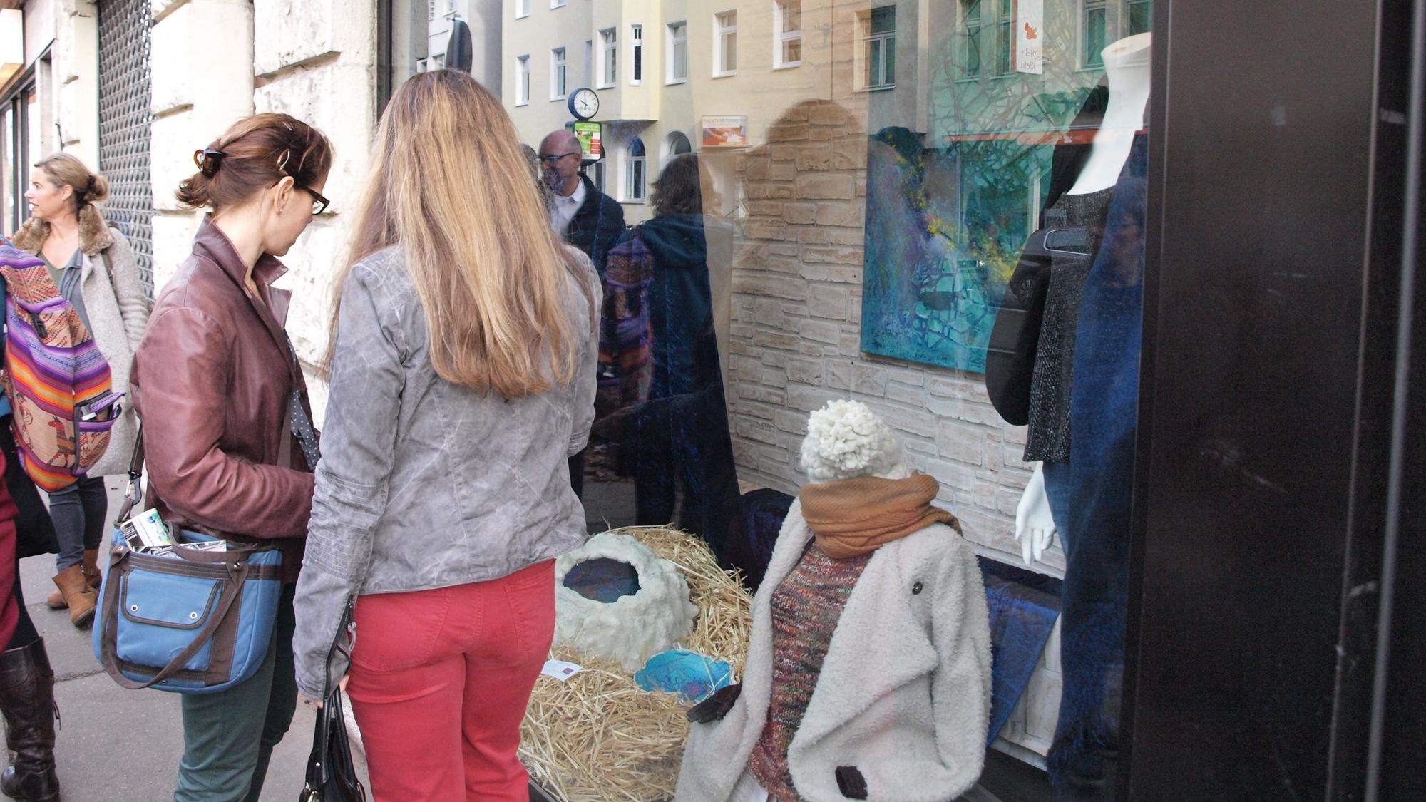 Zwei Frauen stehen vor einem Schaufenster und betrachten die Auslage.