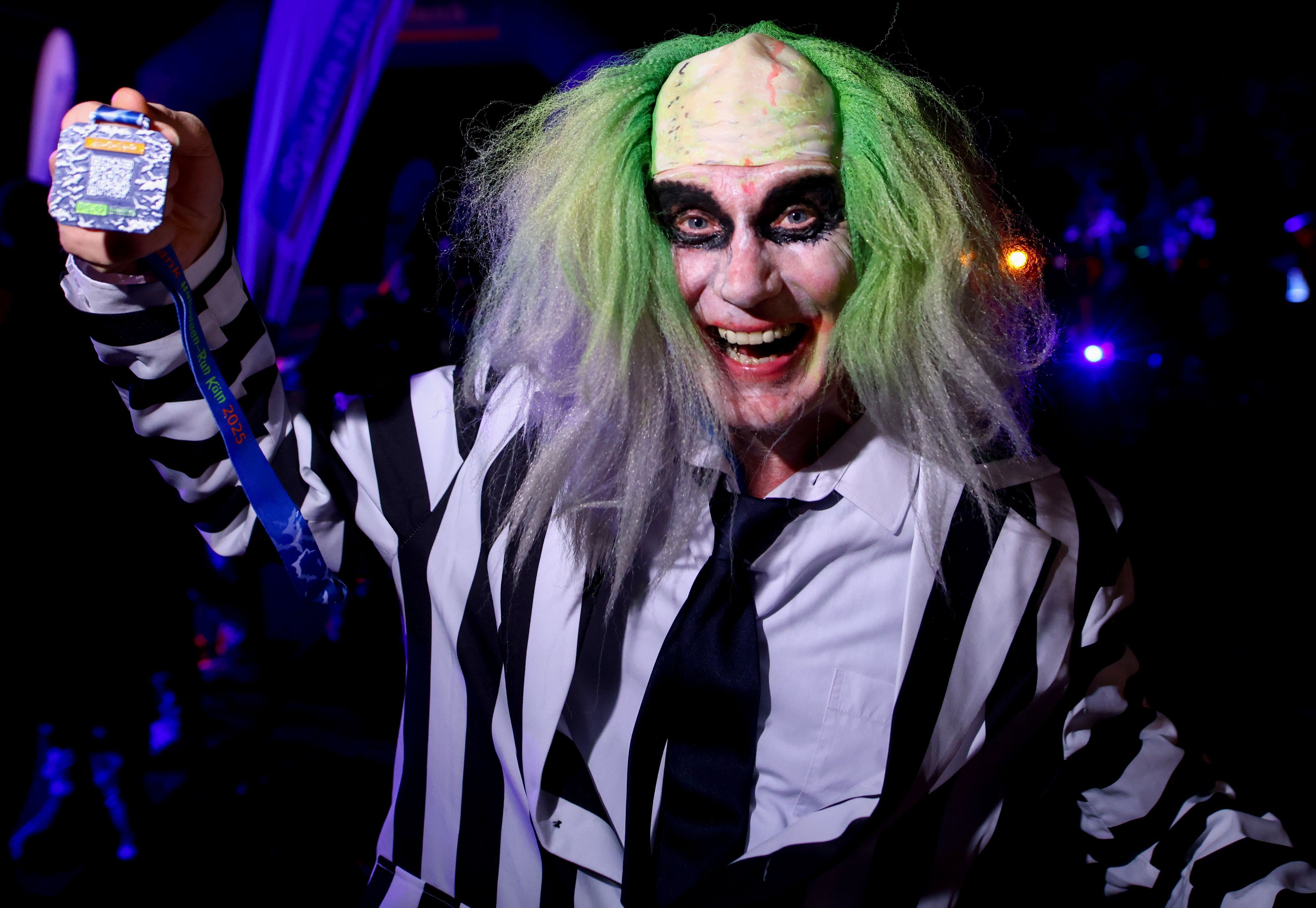 Kostümierte Läufer starten beim Halloween-Run durch den Botanischen Garten bei der im Dunklen auf einer beleuchteten Laufstrecke gelaufen wird - Norbert zeigt seine Medaille.