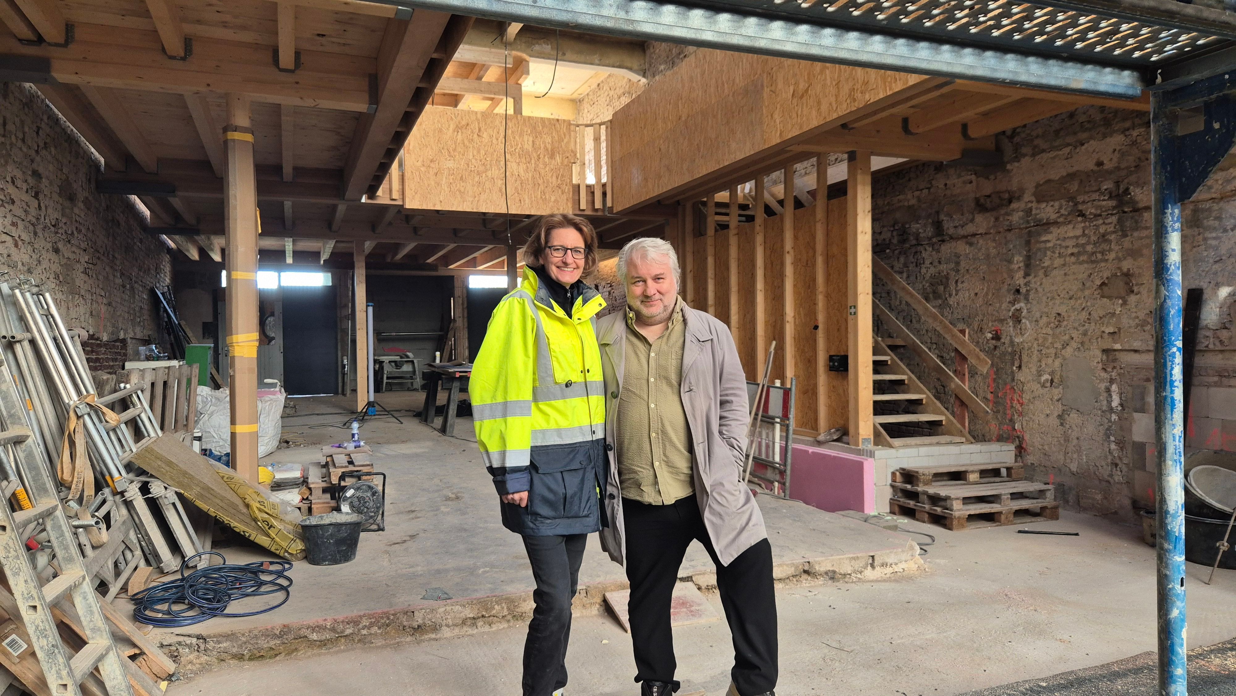 Ein Mann und eine Frau stehen in einer Baustelle.