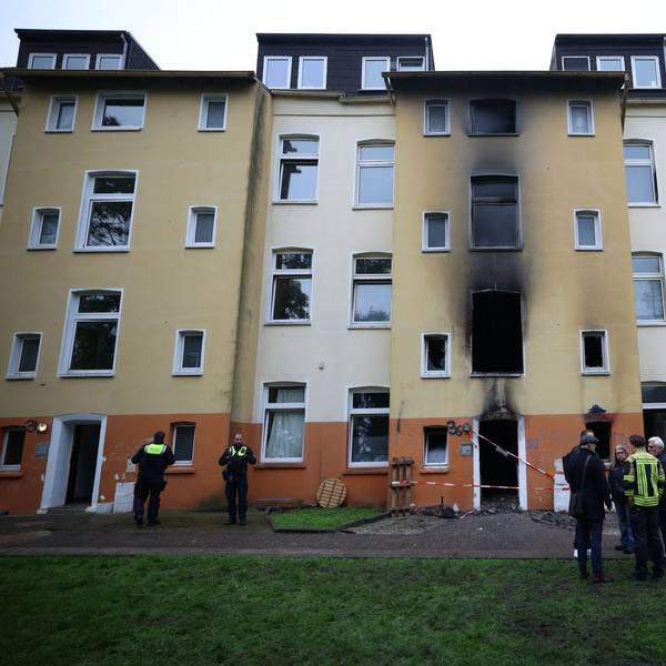 Feuerwehr, Polizei und Brandermittler stehen am Dienstag (13. Oktober) nach einem Brand vor einem Mehrfamilienhaus im Stadtteil Hofstede.