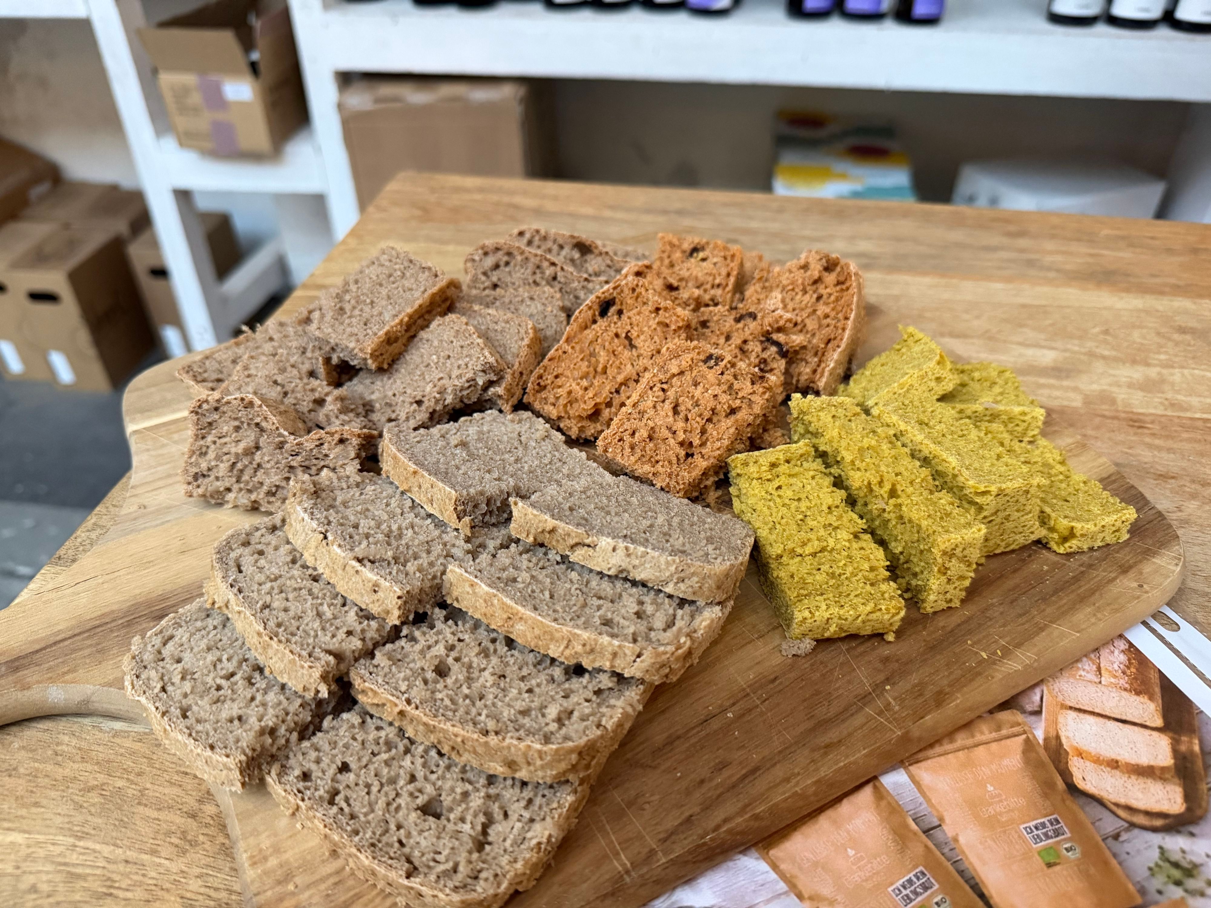 Die 4 Brote aus den Brotbackmischungen des KStA-Genusspaketes fertig gebacken und auf einem Brett serviert.