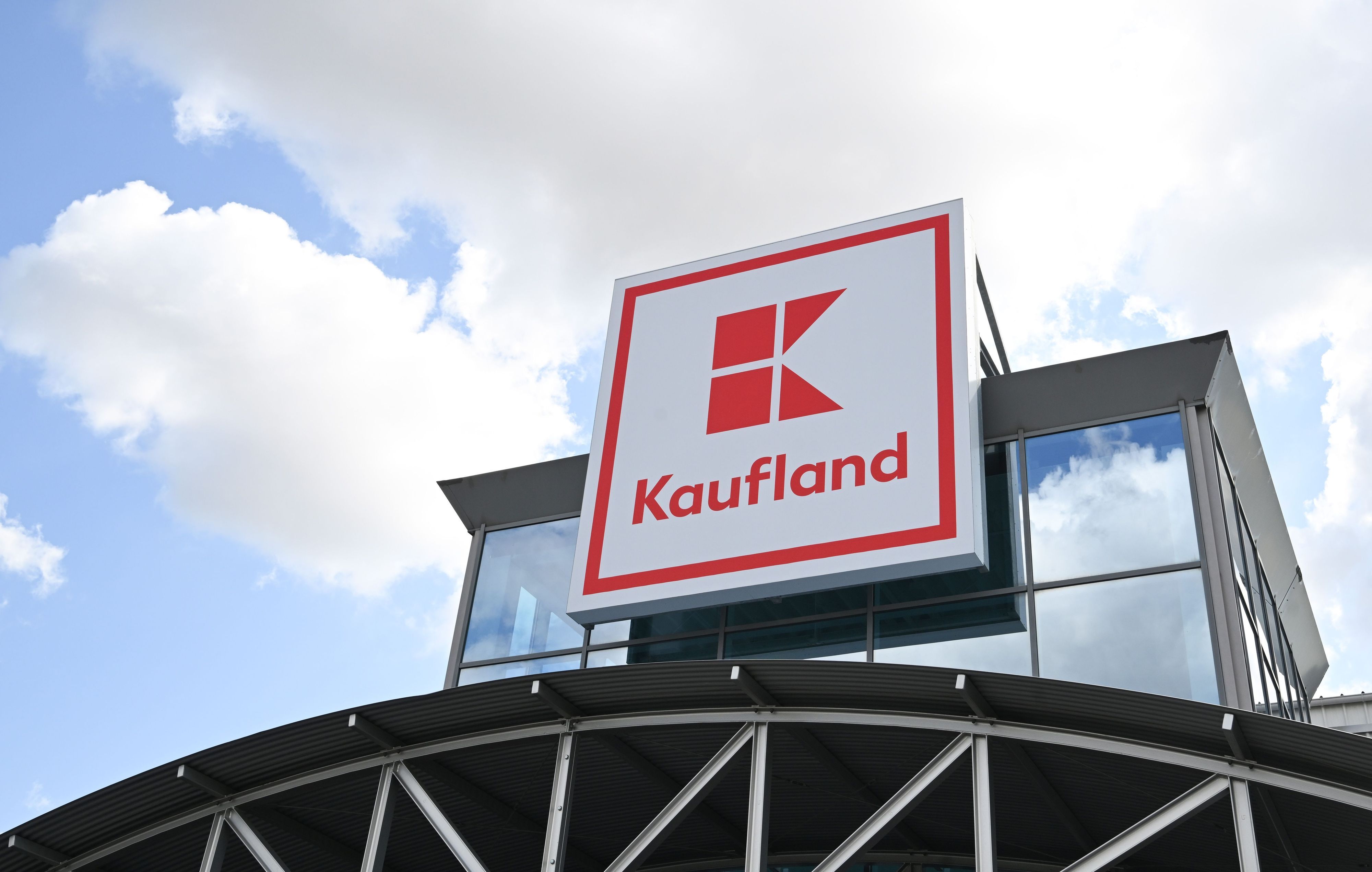 Ein Logo des Lebensmitteländlers Kaufland hängt an einem Haus.