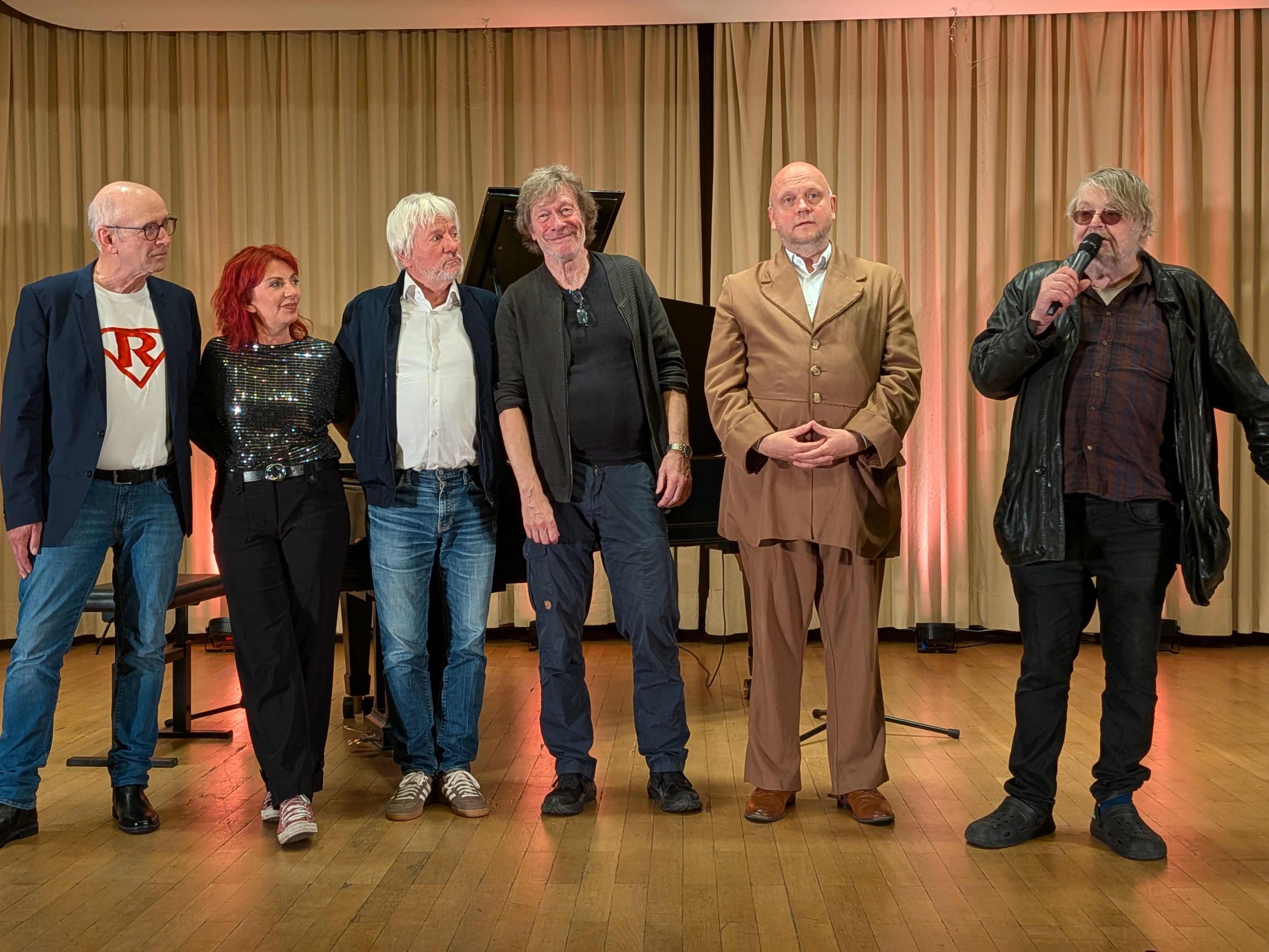 Die Kabarett-Protagonisten und Christian Bechmann stehen auf einer Bühne.