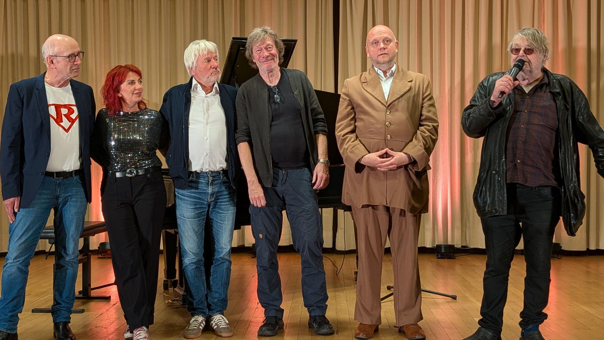 Die Kabarett-Protagonisten und Christian Bechmann stehen auf einer Bühne.