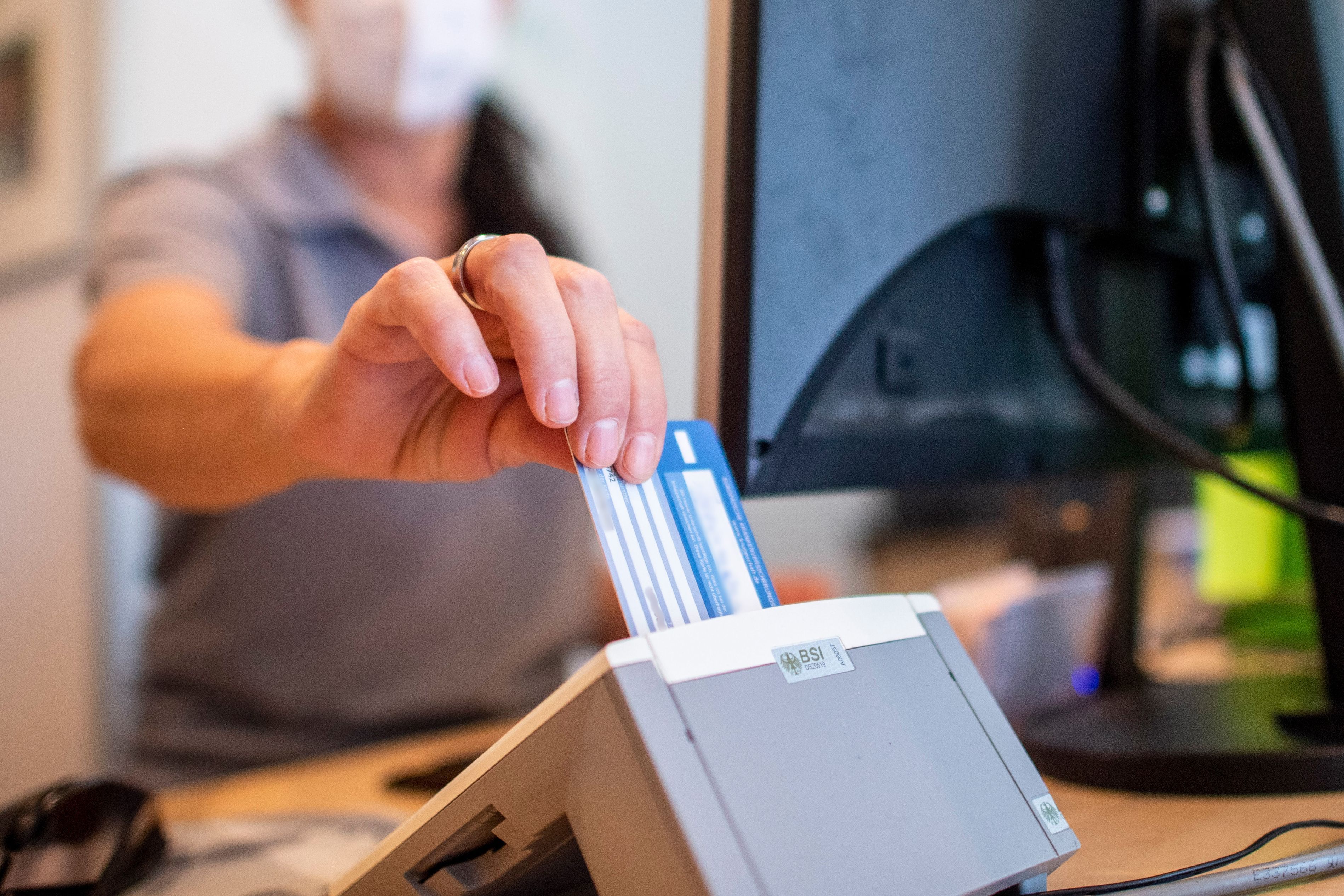 ARCHIV - 01.09.2022, Nordrhein-Westfalen, Münster: Eine Person schiebt eine Versichertenkarte einer Krankenkasse in ein Lesegerät.  (zu dpa: «Pflegebranche beklagt hohen Aufwand nur fürs Karten-Einlesen») Foto: David Inderlied/dpa +++ dpa-Bildfunk +++