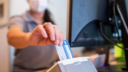 ARCHIV - 01.09.2022, Nordrhein-Westfalen, Münster: Eine Person schiebt eine Versichertenkarte einer Krankenkasse in ein Lesegerät. (zu dpa: «Pflegebranche beklagt hohen Aufwand nur fürs Karten-Einlesen») Foto: David Inderlied/dpa +++ dpa-Bildfunk +++