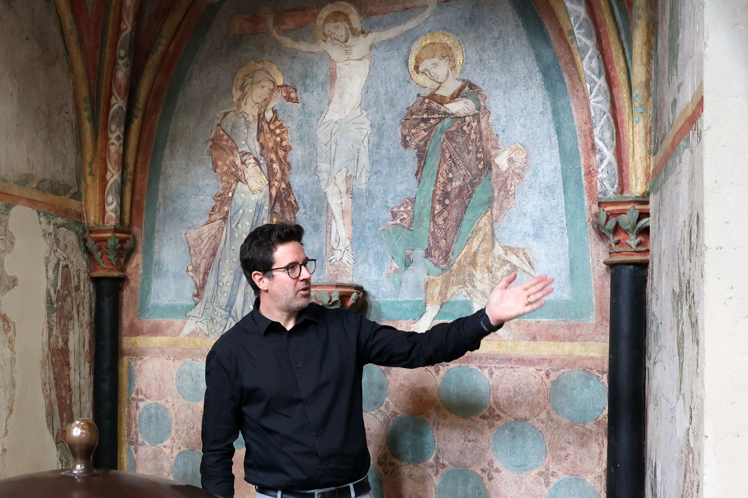 Kunsthistoriker Adam Stead vor den mittelalterlichen Wandmalereien in der Taufkapelle von St. Kunibert.