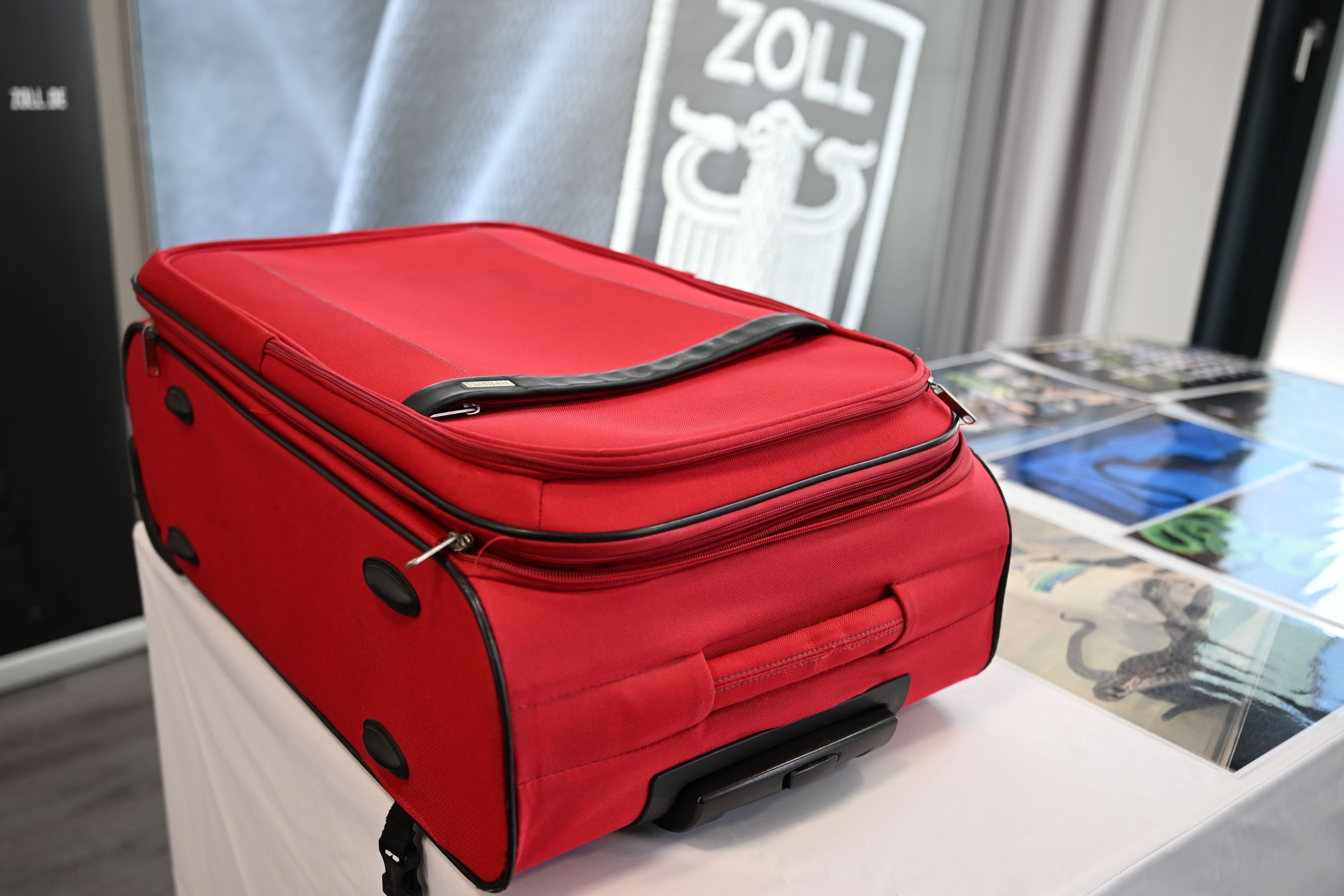 15.10.2026, Nordrhein-Westfalen, Köln: Ein roter Koffer, in dem Schlangen und Echsen versteckt waren, liegt auf einem Tisch. Der Zoll hat bei einer Kontrolle auf dem Flughafen mehr als neunzig lebende Giftschlangen und Echsen in einem Koffer gefunden. (zu dpa: «Giftschlangen in Shampoo-Flaschen, Echsen in Socken») Foto: Federico Gambarini/dpa +++ dpa-Bildfunk +++