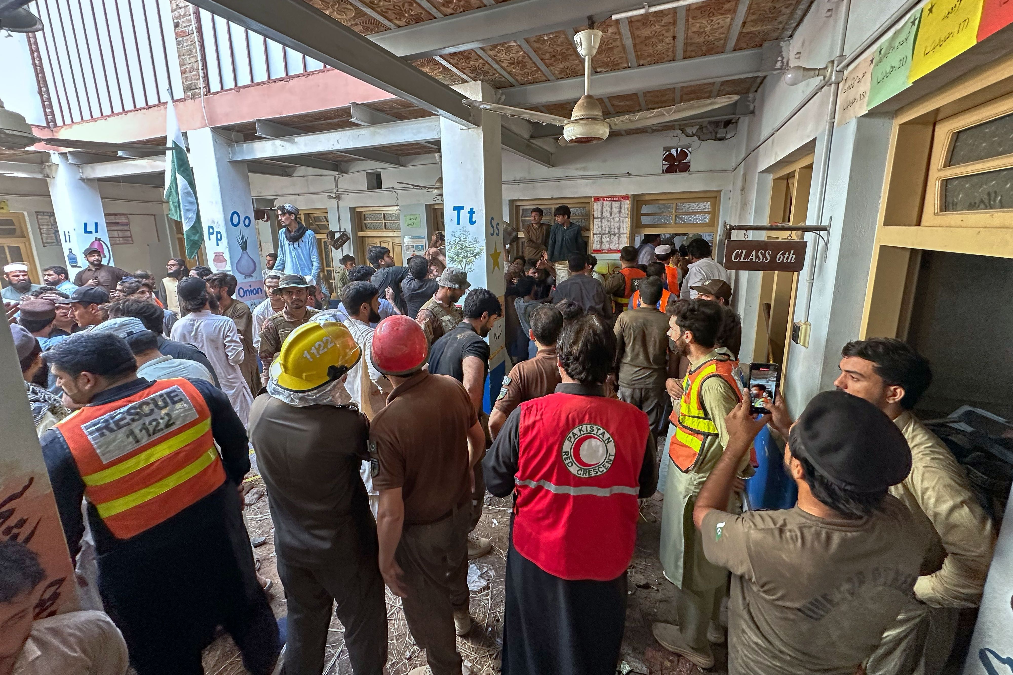 Rettungskräfte und Freiwillige beteiligen sich an den Rettungsarbeiten am Ort eines Dacheinsturzes an einer Privatschule in Peshawar.