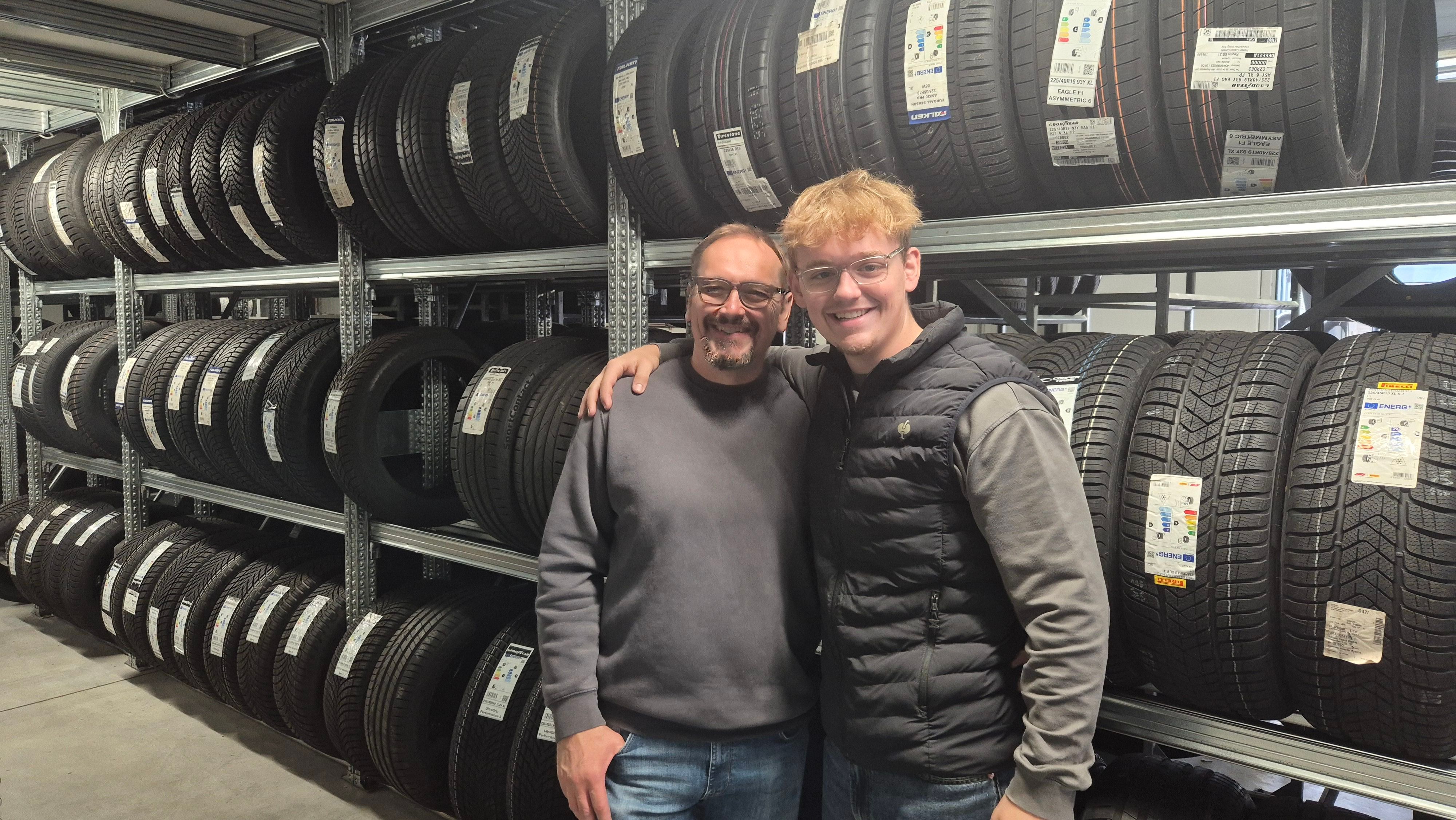 Vater und Sohn Berg stehen vor Reifen-Regalen.
