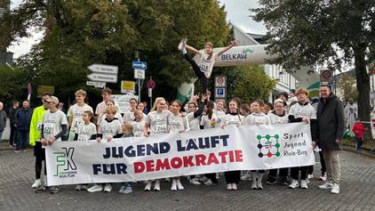 Jugendliche Läufer mit Banner beim Burscheider Stadtlauf