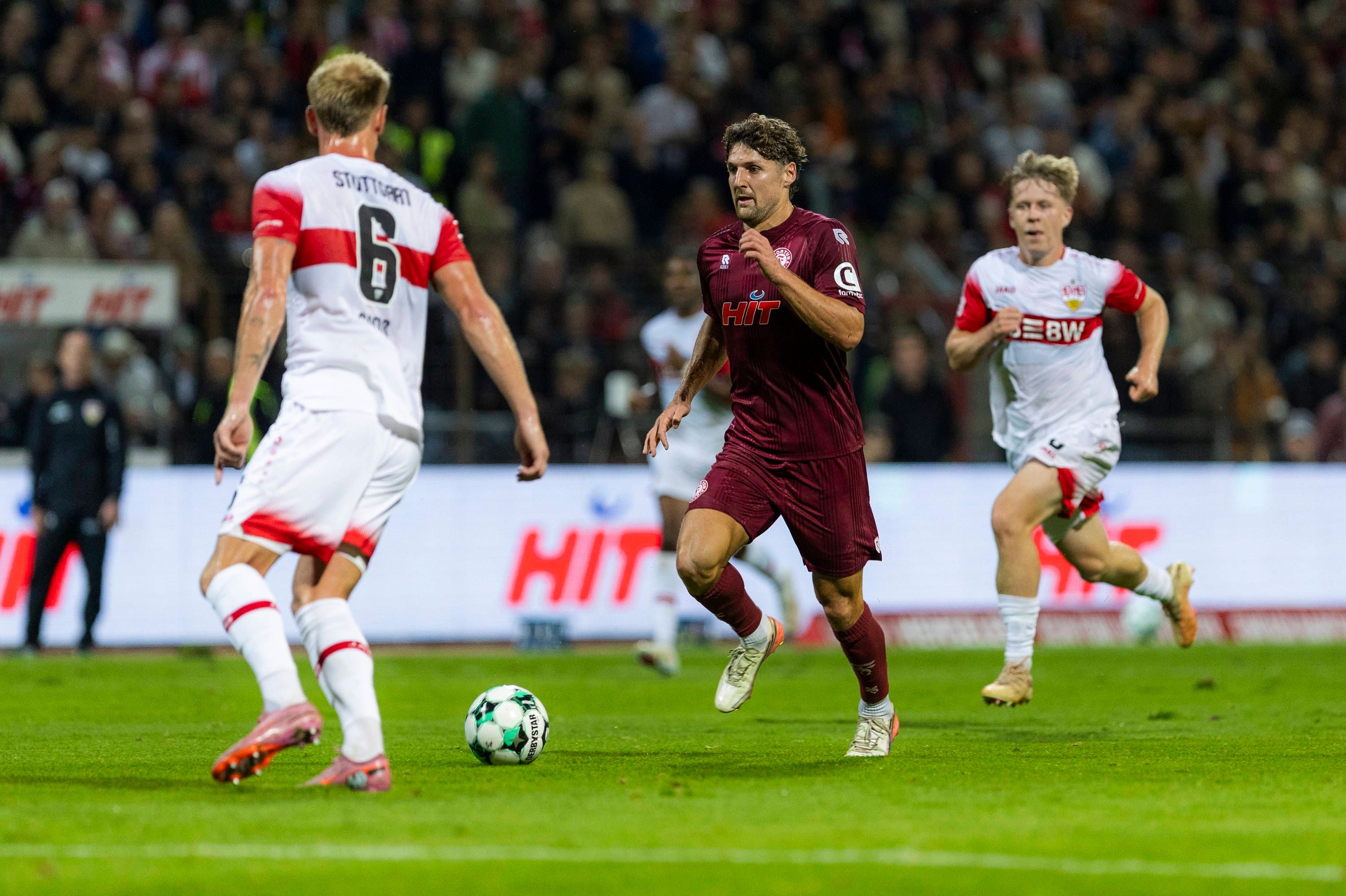 Enzo Wirtz führt den Ball zwischen zwei Stuttgartern.