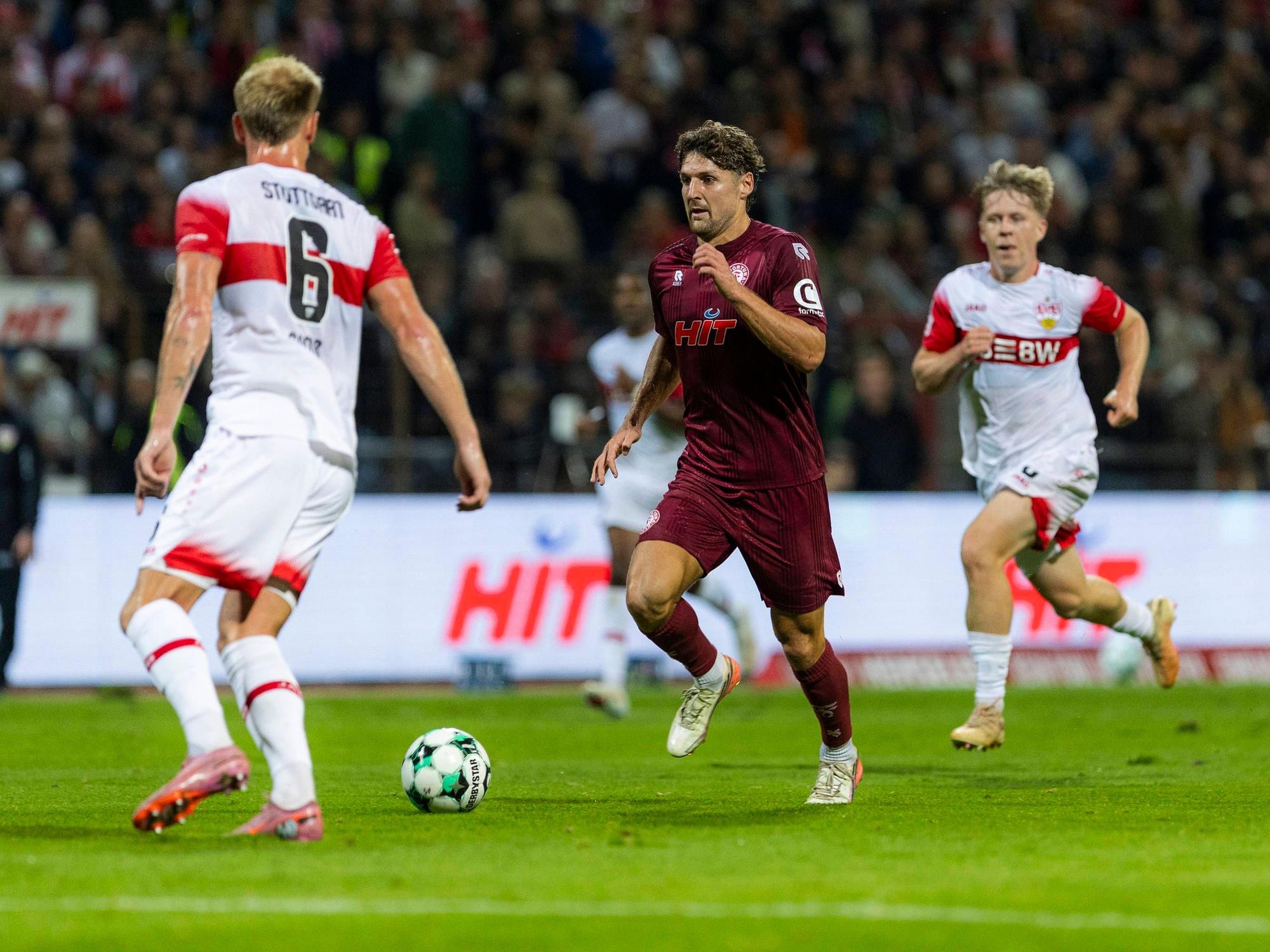 Enzo Wirtz führt den Ball zwischen zwei Stuttgartern.