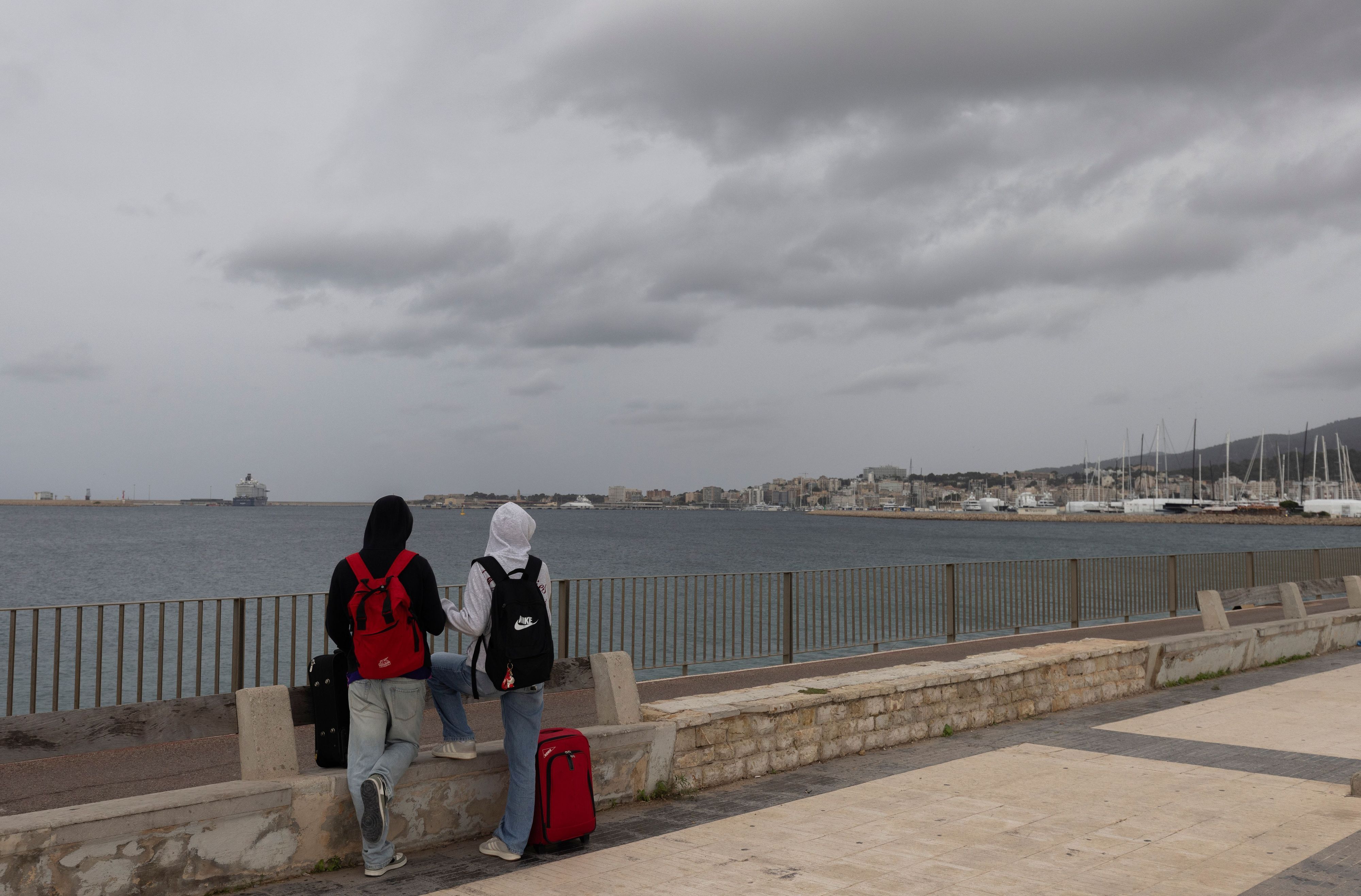 Menschen am Meer auf der Strandpromenade von Palma. Der Sturm „Adam“ zieht über die Insel hinweg, und für die Bevölkerung wurde eine rote Warnstufe ausgerufen.