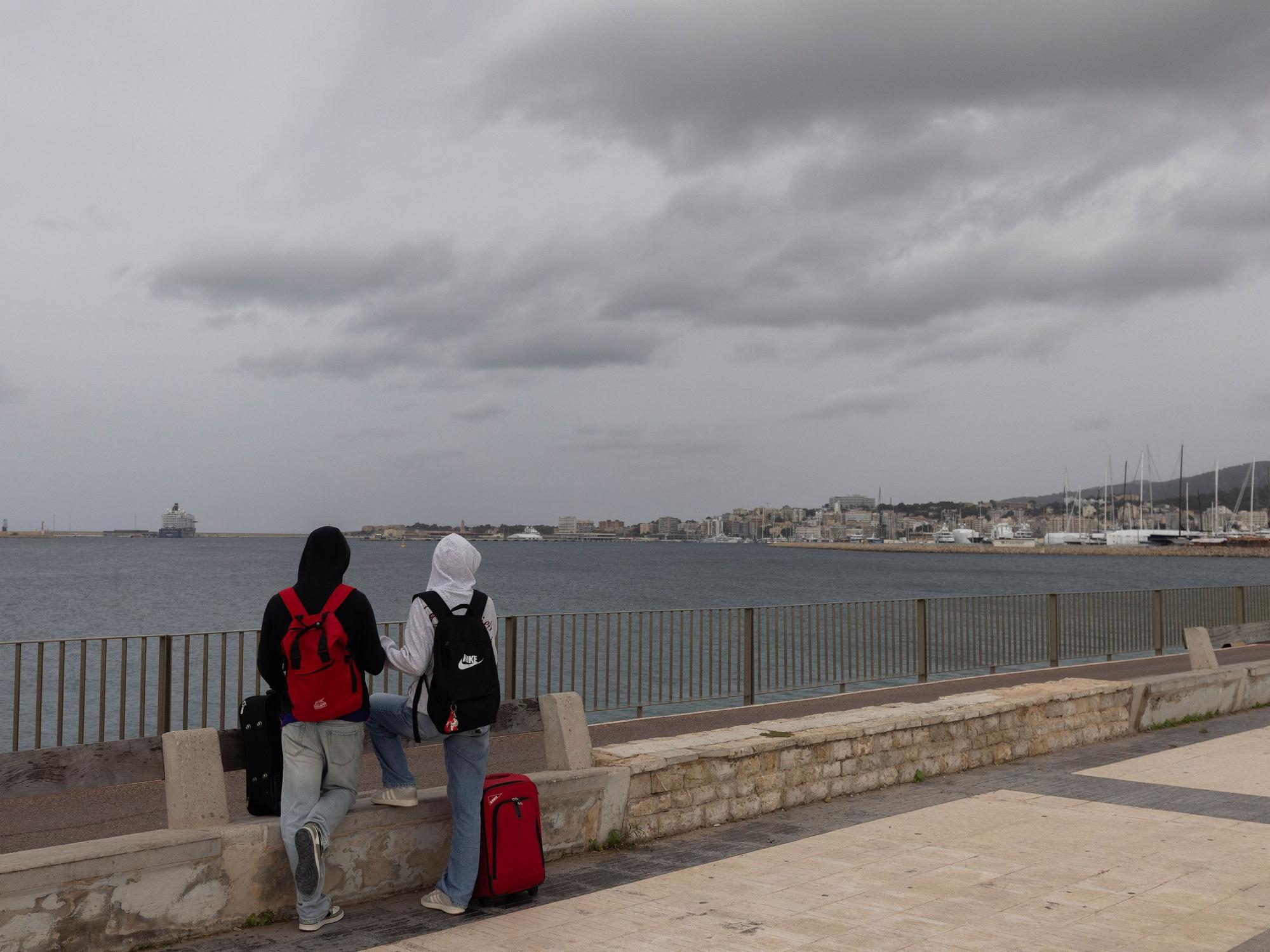 Menschen am Meer auf der Strandpromenade von Palma. Der Sturm „Adam“ zieht über die Insel hinweg, und für die Bevölkerung wurde eine rote Warnstufe ausgerufen.