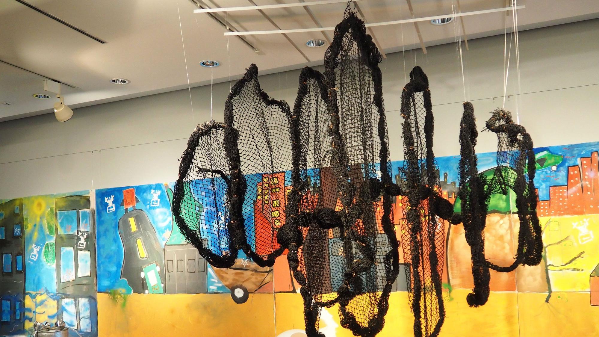 Die Installation aus einem alten Fangnetz ist der Blickfang der Ausstellung. Das Bild dahinter ist in diversen Techniken entstanden.