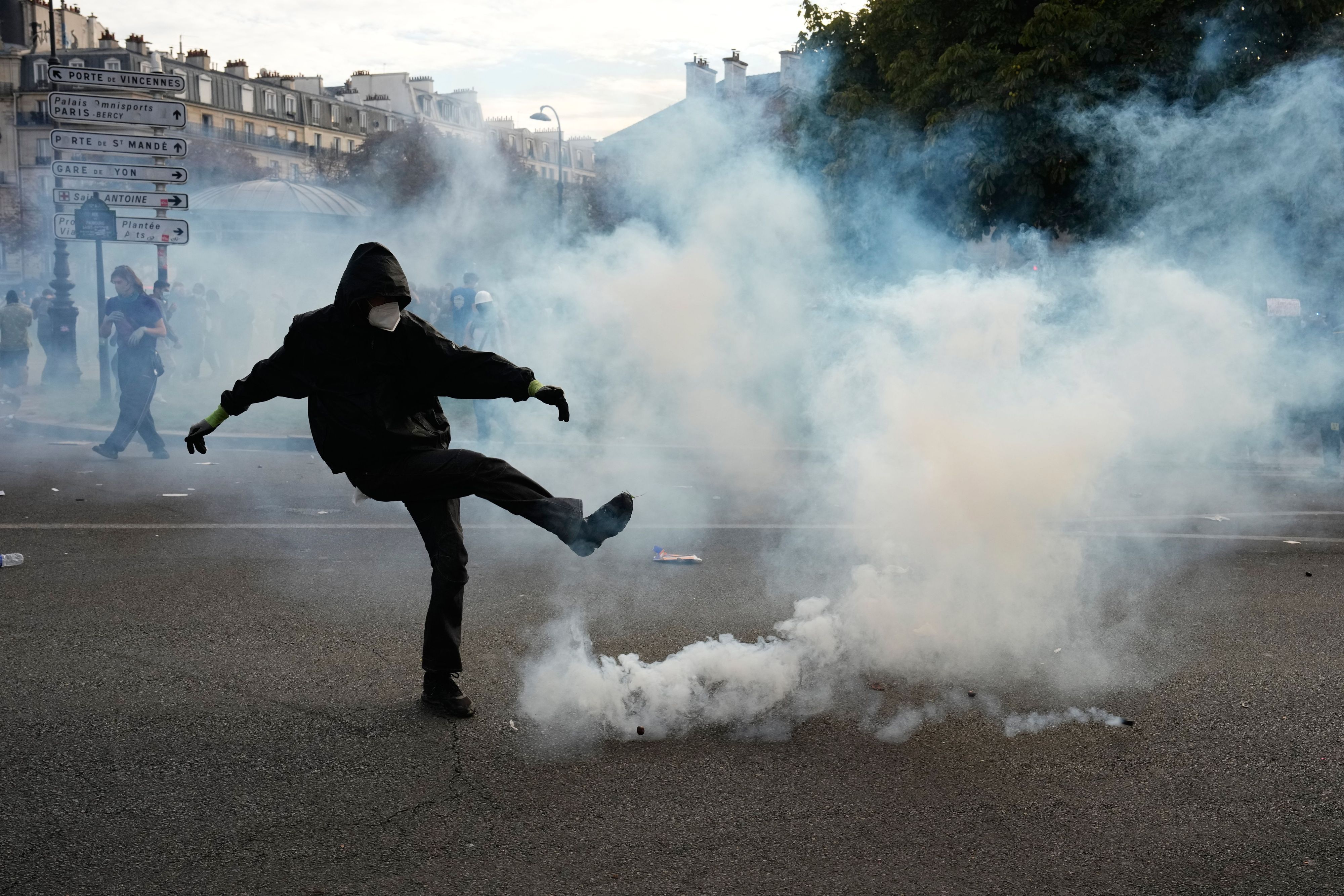 Ein Demonstrant tritt während Ausschreitungen im Anschluss an eine Demonstration gegen unterfinanzierte Schulen gegen eine Tränengasgranate.