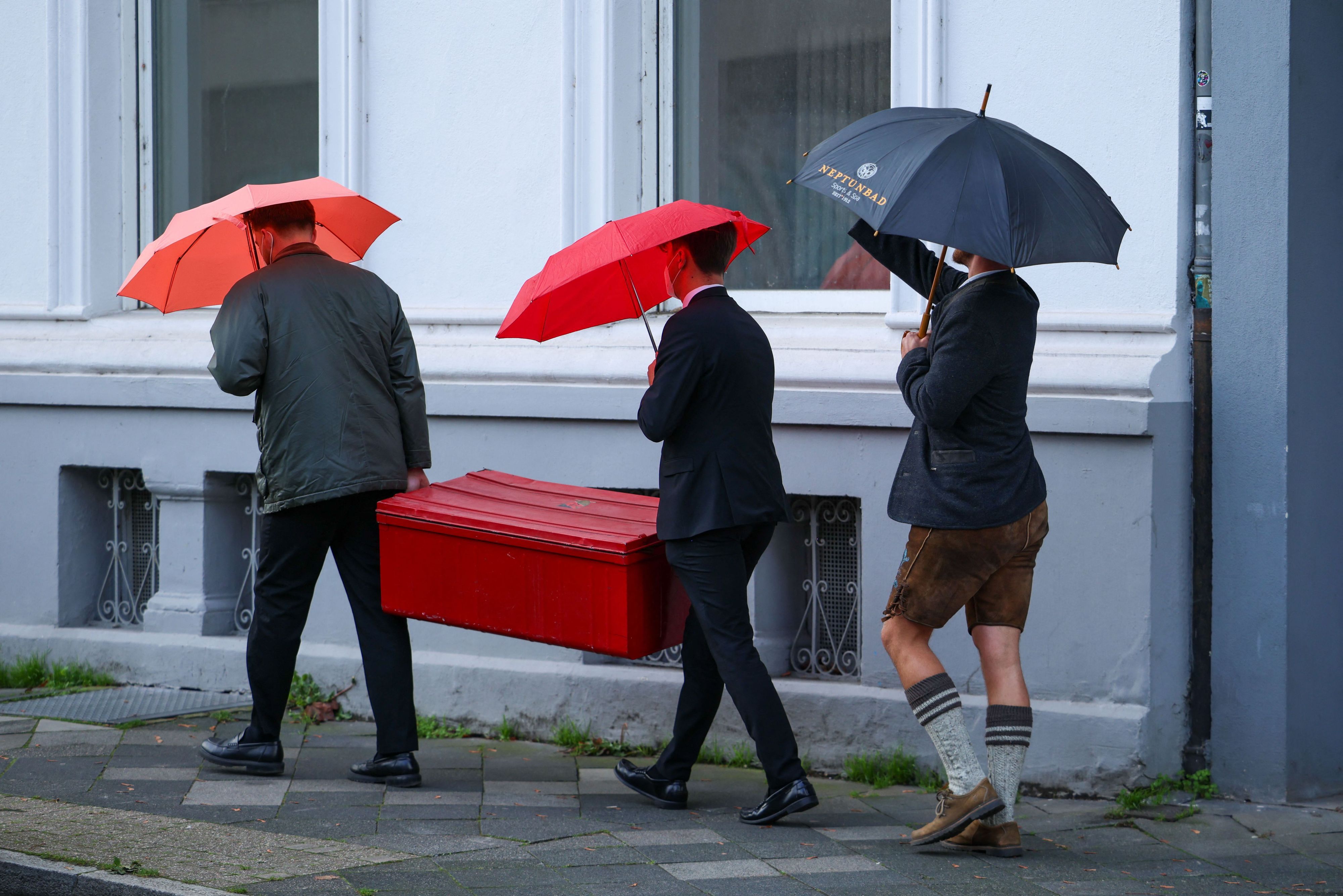 Drei Männer trugen am Samstag eine Mensurkiste zu einem Haus, in dem die schlagende Verbindung in Düsseldorf ihren Sitz hat.