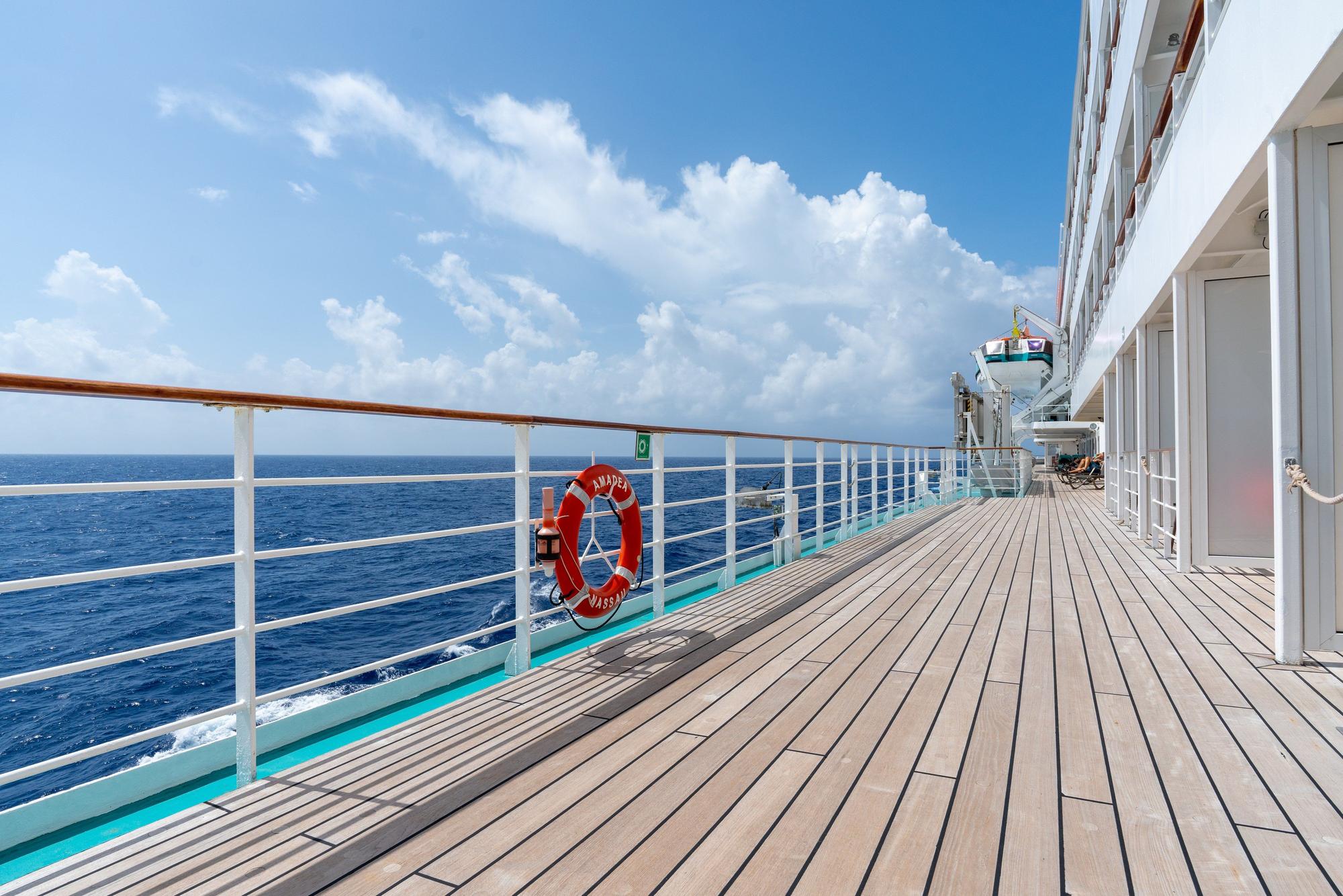 Promenadendeck der MS AMADEA mit Rettungsring und Blick auf das Meer.
