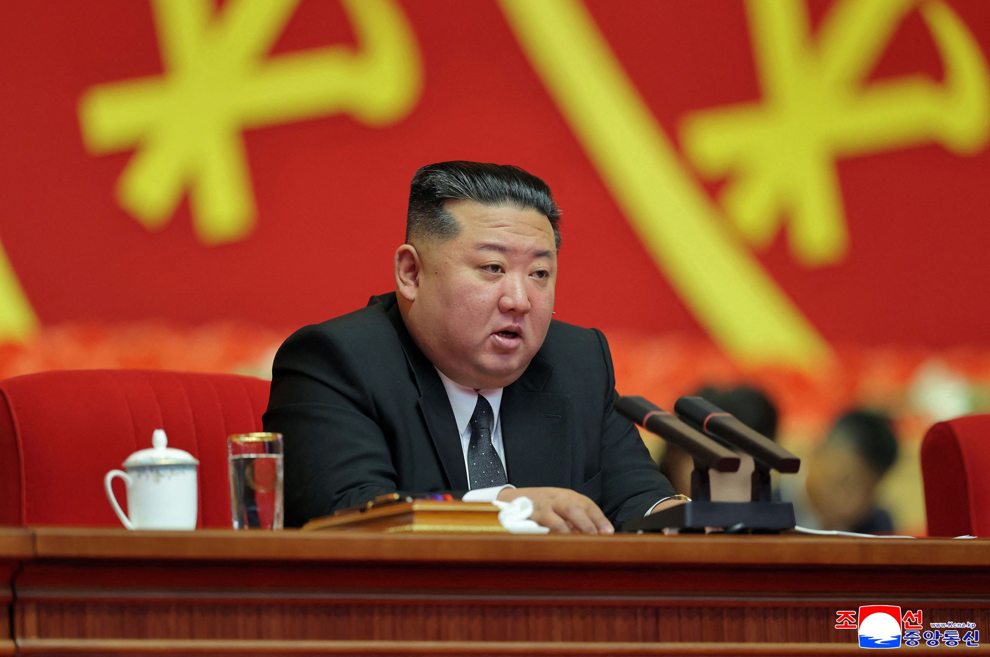 Nordkoreas Diktator Kim Jong Un spricht am Rednerpult.