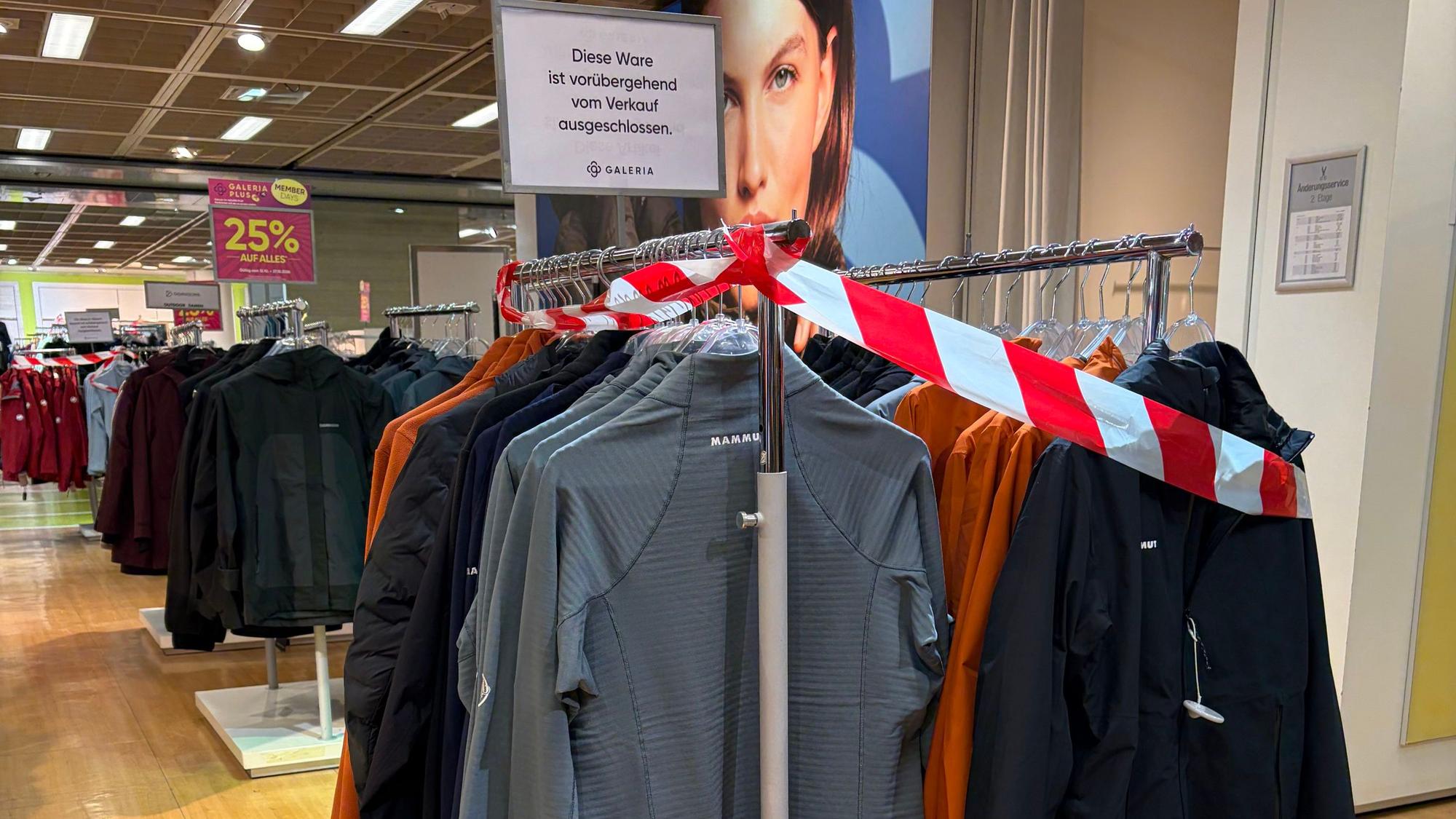 Ware im Galeria-Kaufhaus an der Hohe Straße in Köln ist mit rot-weißem Flatterband abgesperrt. Ein Schild weist darauf hin, dass die Kleidung vorübergehend vom Verkauf ausgeschlossen ist.