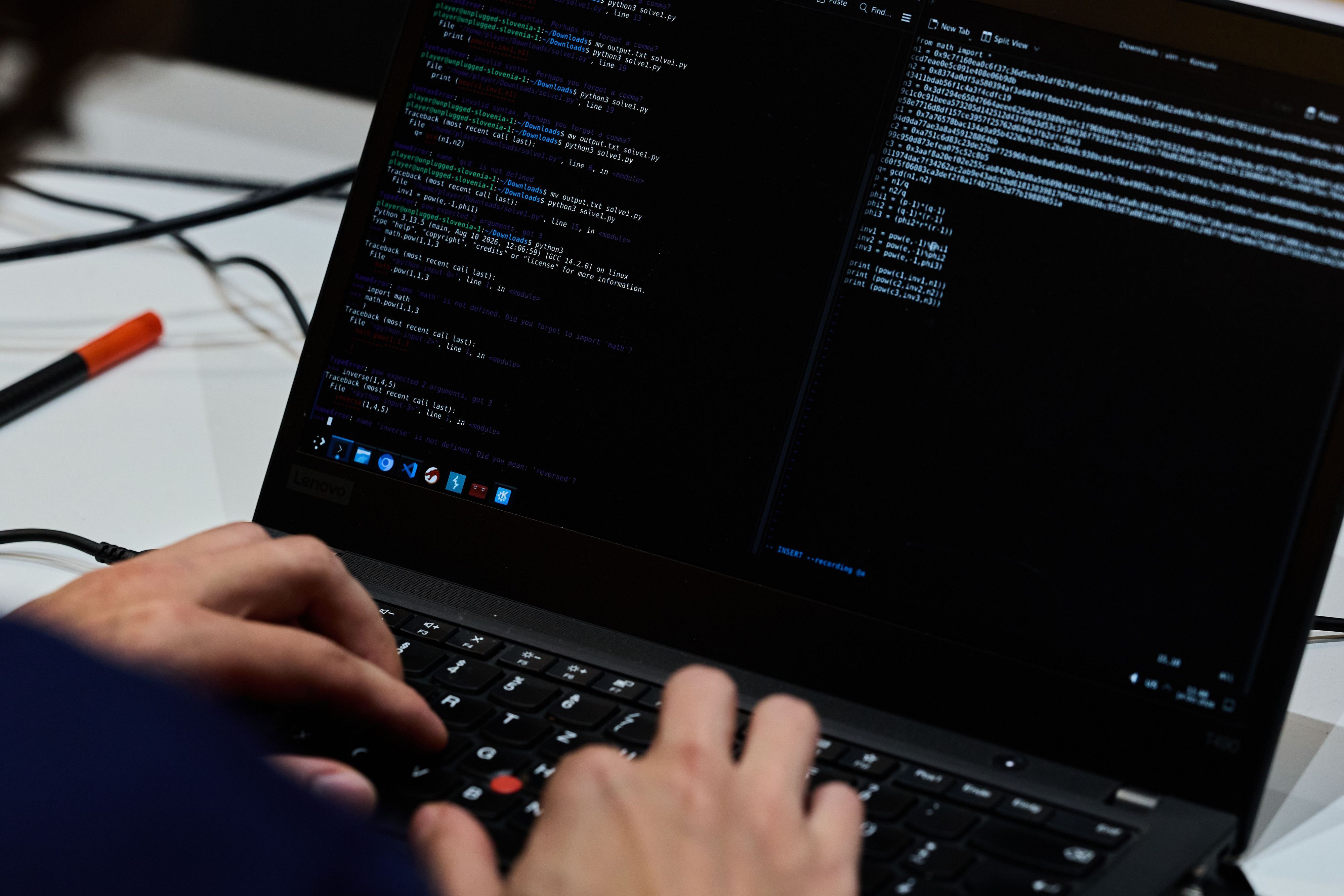 Symbolbild: Hand vor dem Laptop, auf dem Codes zu sehen sind.