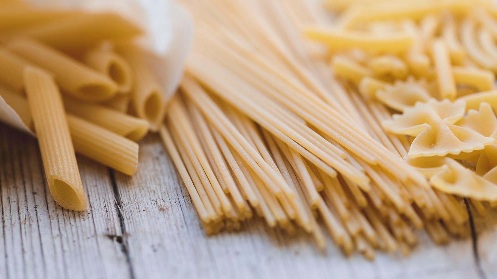 Verschiedene Nudeln liegen auf einem Holztisch. Die Pasta Sassella Tartero GmbH aus Rheinbach ist insolvent.
