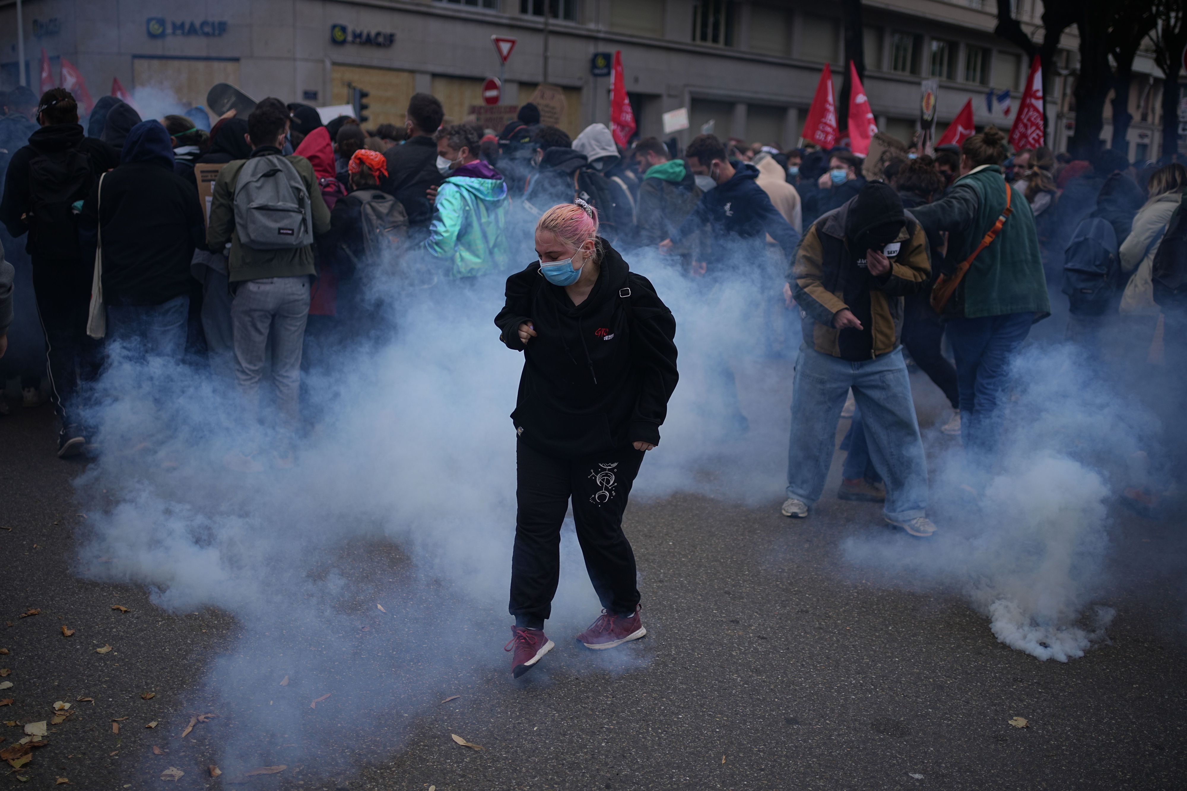 Demonstranten stehen während einer Demonstration gegen steigende Lebenshaltungskosten in Lyon im Tränengas.