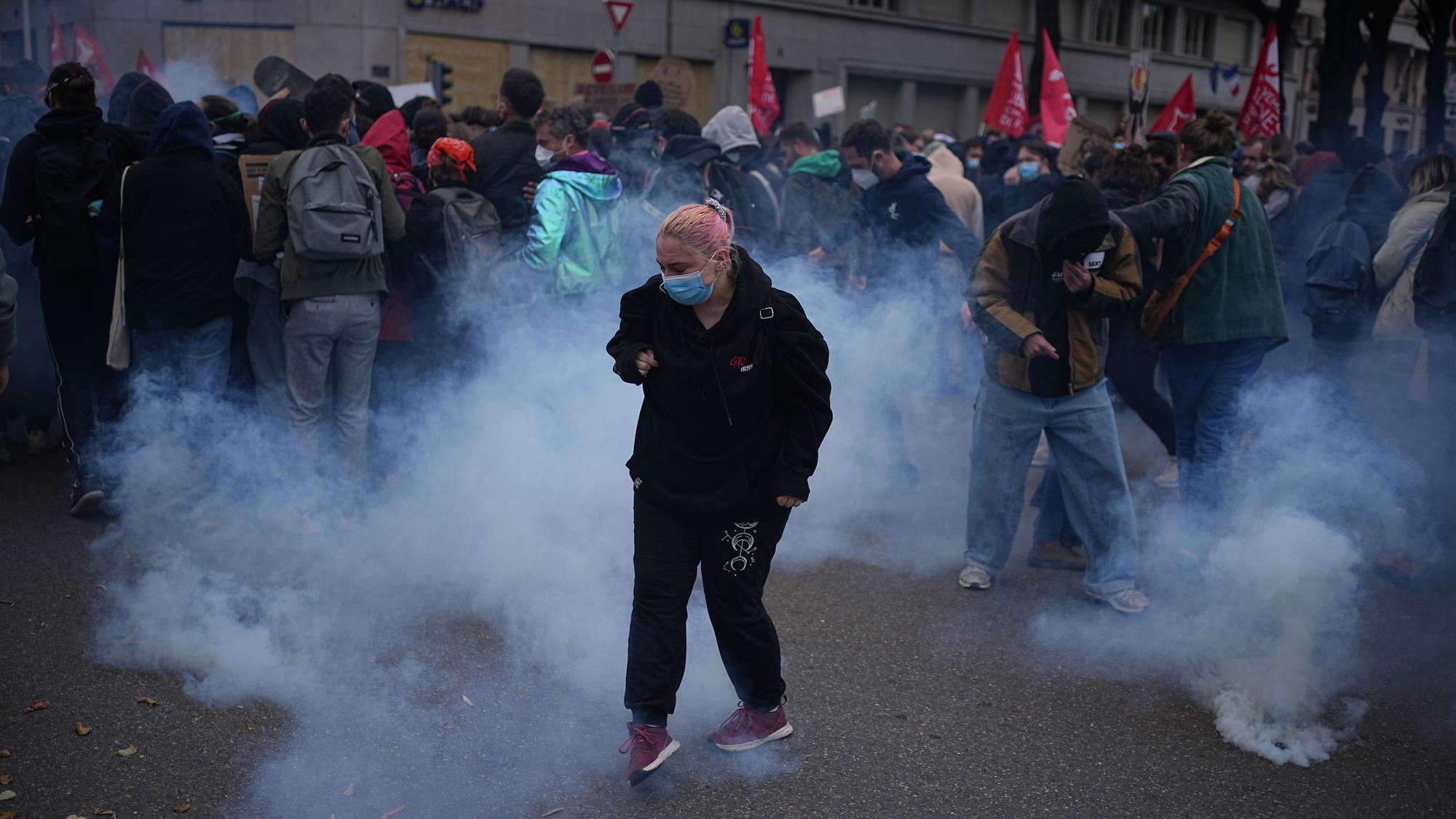 Demonstranten stehen während einer Demonstration gegen steigende Lebenshaltungskosten in Lyon im Tränengas.