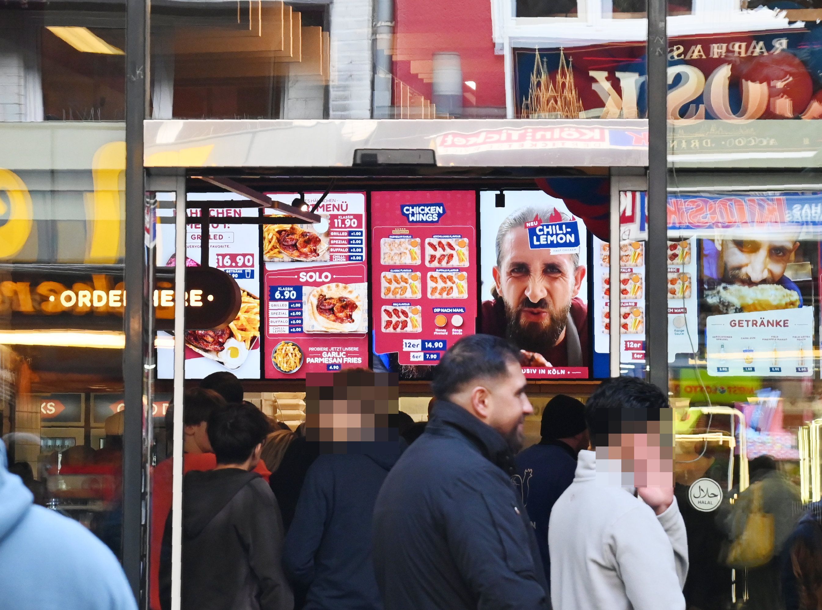 20.10.2026 Köln. Der Fast-Food-Imbiss Nhas City Chicken an der Breite Straße hat Ende September eröffnet. Noch immer bilden sich zeitweise Warteschlange vor dem Laden, der inbesondere durch Social Media seine Aufmerksamkeit bezieht. Foto: Alexander Schwaiger