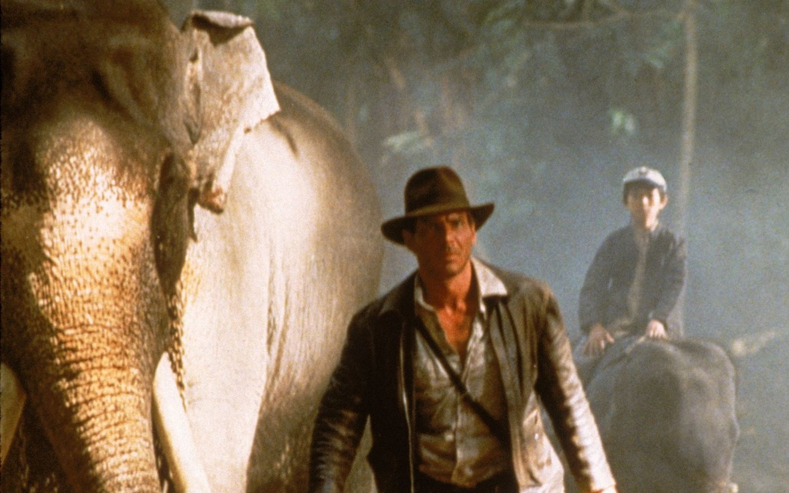 Auf Elefanten machen sich Indy (Harrison Ford, links) und Shorty (Jonathan Ke Quan) auf den Weg zum Palast des Maharadschas von Pankot. (Bild: ProSieben / Paramount Pictures)