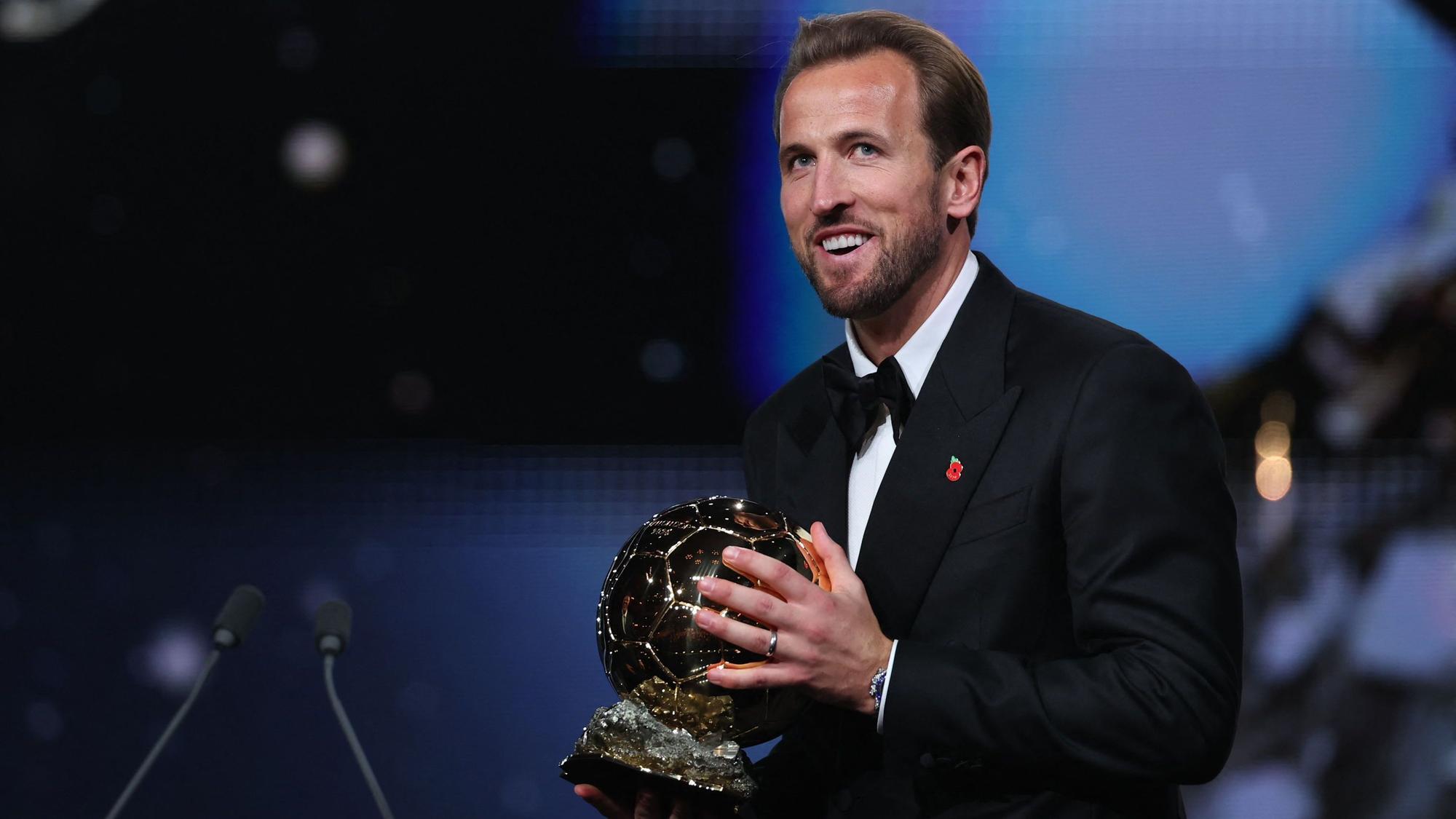 Auf der Bühne hält Weltfußballer Harry Kane den Ballon d'Or in den Händen.