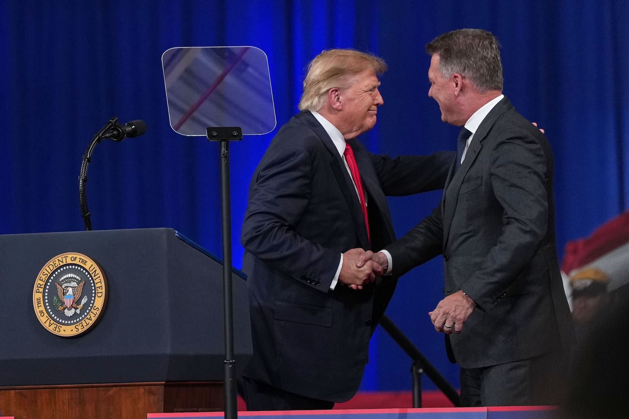 Ein viel kritisierter Handschlag: US-Präsident Donald Trump begrüßt Audi-Chef Gernot Döllner bei einem Wahlkampfauftritt in Georgia.