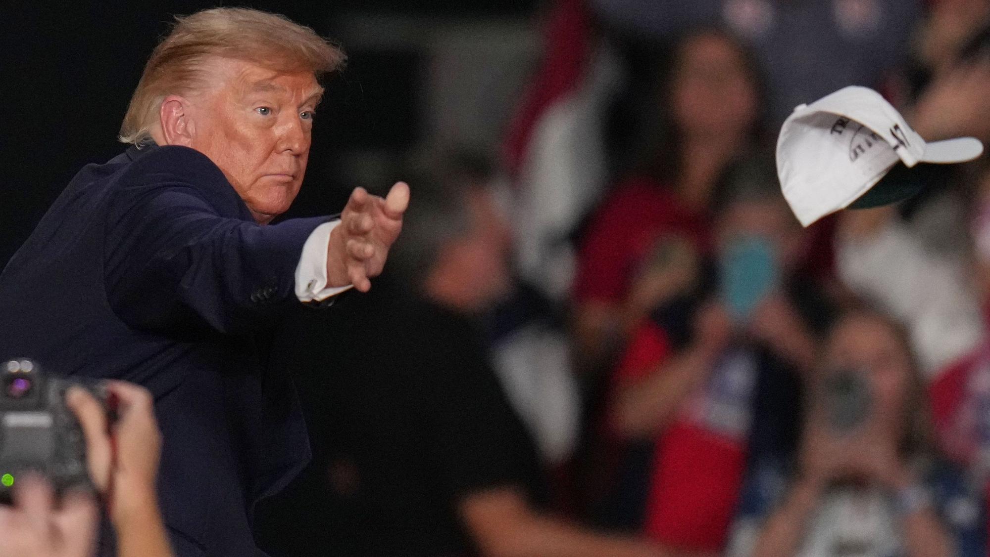 dpatopbilder - 26.10.2026, USA, Korinth: US-Präsident Donald Trump wirft bei einer Wahlkampfveranstaltung in der Crossroads Arena Kappen in die Menge. Foto: Jeff Roberson/AP/dpa +++ dpa-Bildfunk +++