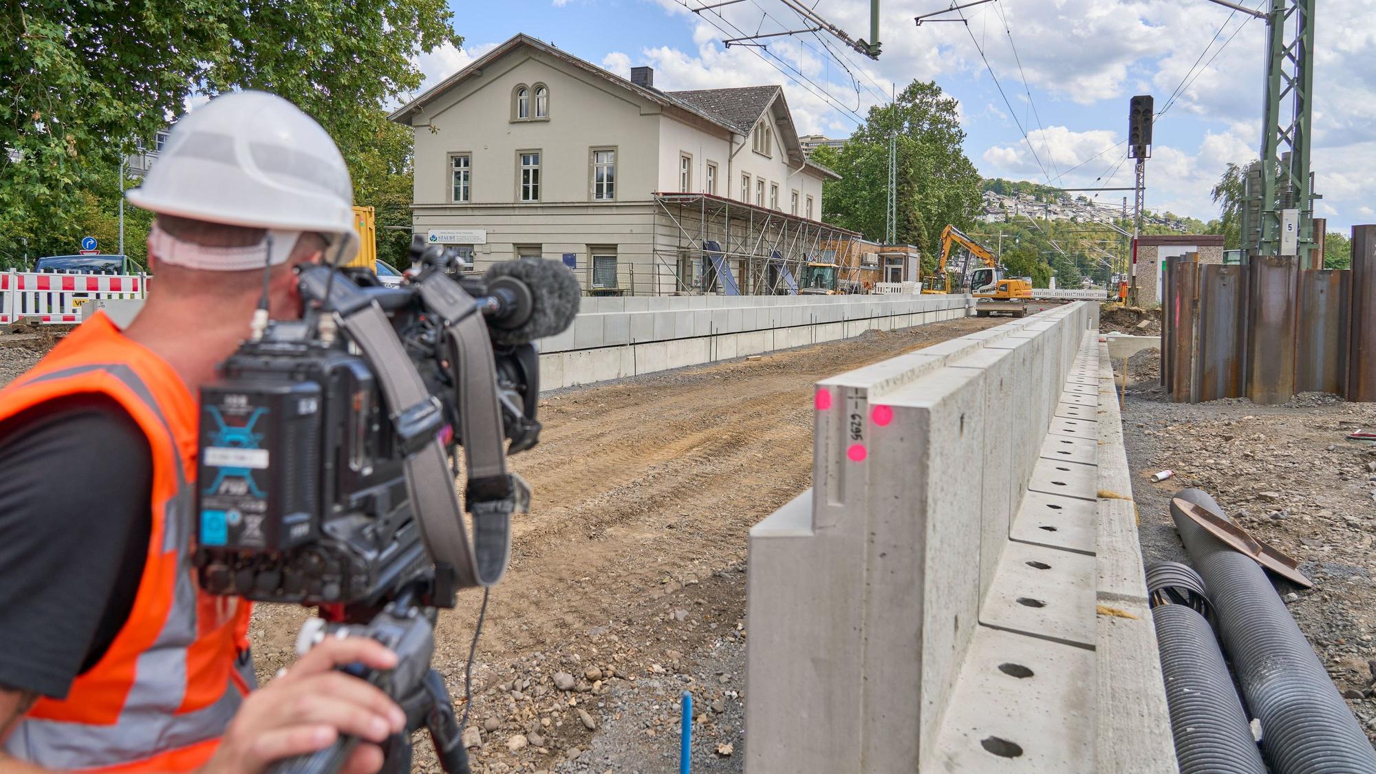ARCHIV - 05.08.2026, Rheinland-Pfalz, Neuwied: Ein Kameramann macht eine Aufnahme. Die Generalsanierung der Bahnstrecke zwischen Troisdorf und Wiesbaden ist seit wenigen Wochen im vollen Gang. Der neue Bahnsteig am Haltepunkt in Vallendar bei Koblenz ist bereits gut zu erkennen. Ein Kameramann filmt die Arbeiten. (zu dpa: «Bahn saniert linke Rheinstrecke 2028 nur zum Teil») Foto: Sascha Ditscher/dpa +++ dpa-Bildfunk +++