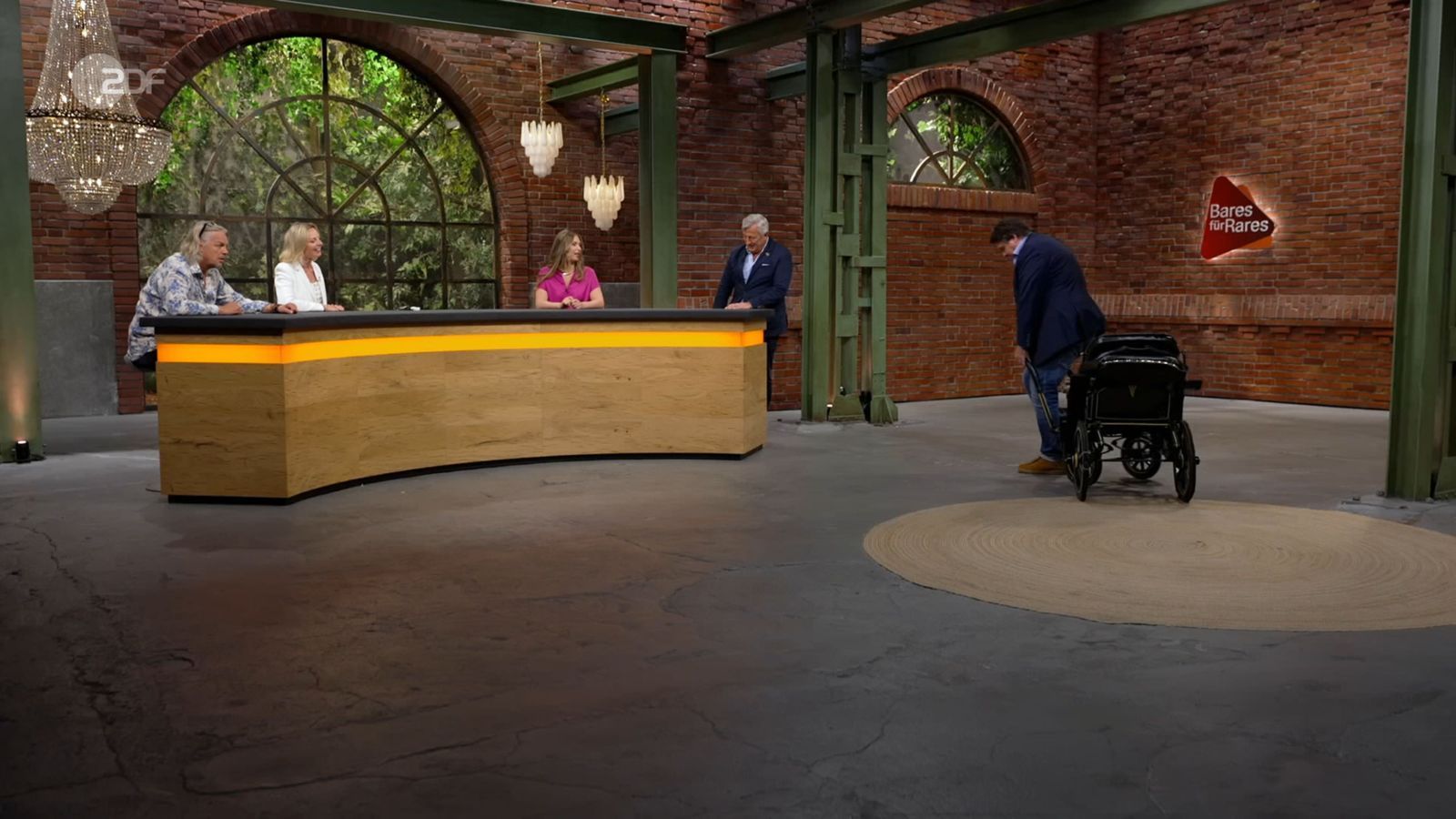 Daniel Meyer musste in die Knie gehen, um die Kutsche testweise zu ziehen: „Für Menschen ist es, glaube ich, nicht.“ Susanne Steiger neckte ihn: „Steht dir, Daniel.“ Sarah Schreiber machte ebenfalls einen Scherz ... (Bild: ZDF)