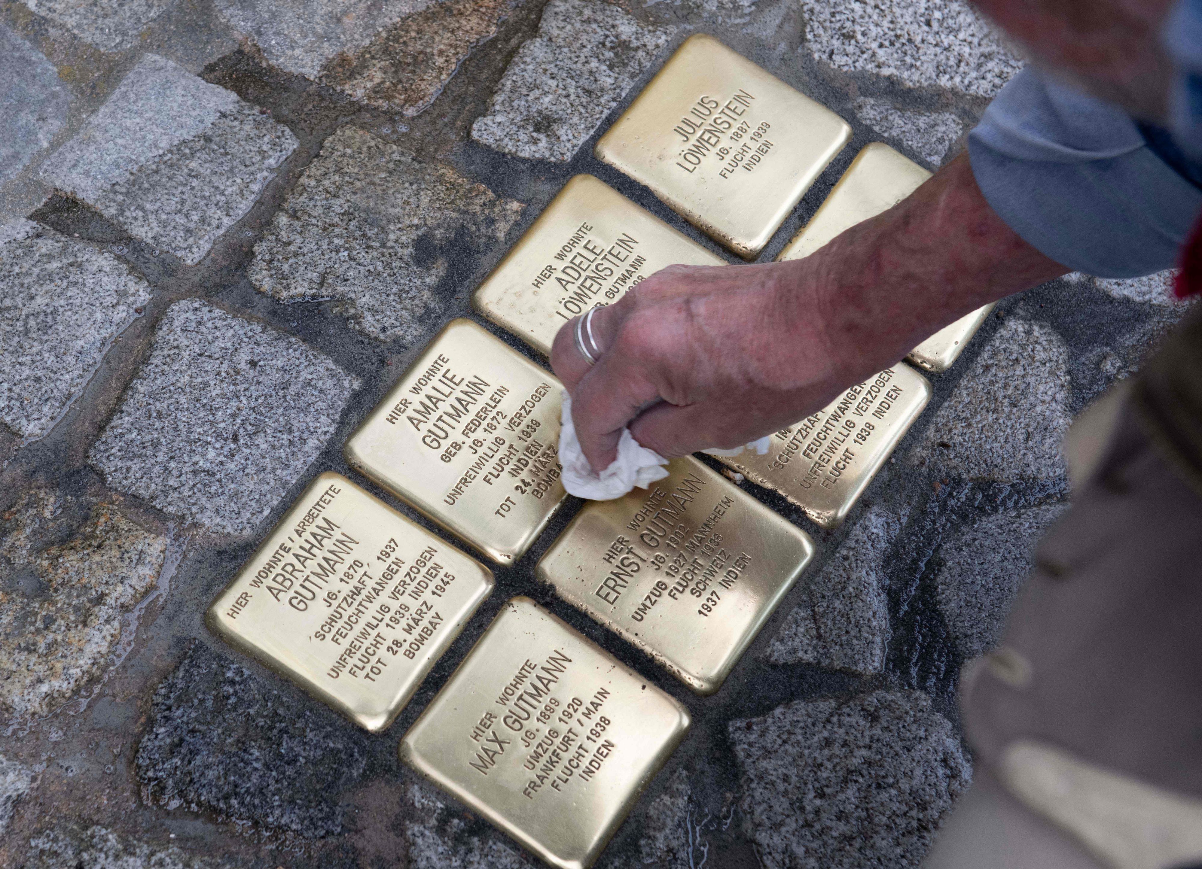 Stolpersteine von 8 jüdischen Menschen werden geputzt.