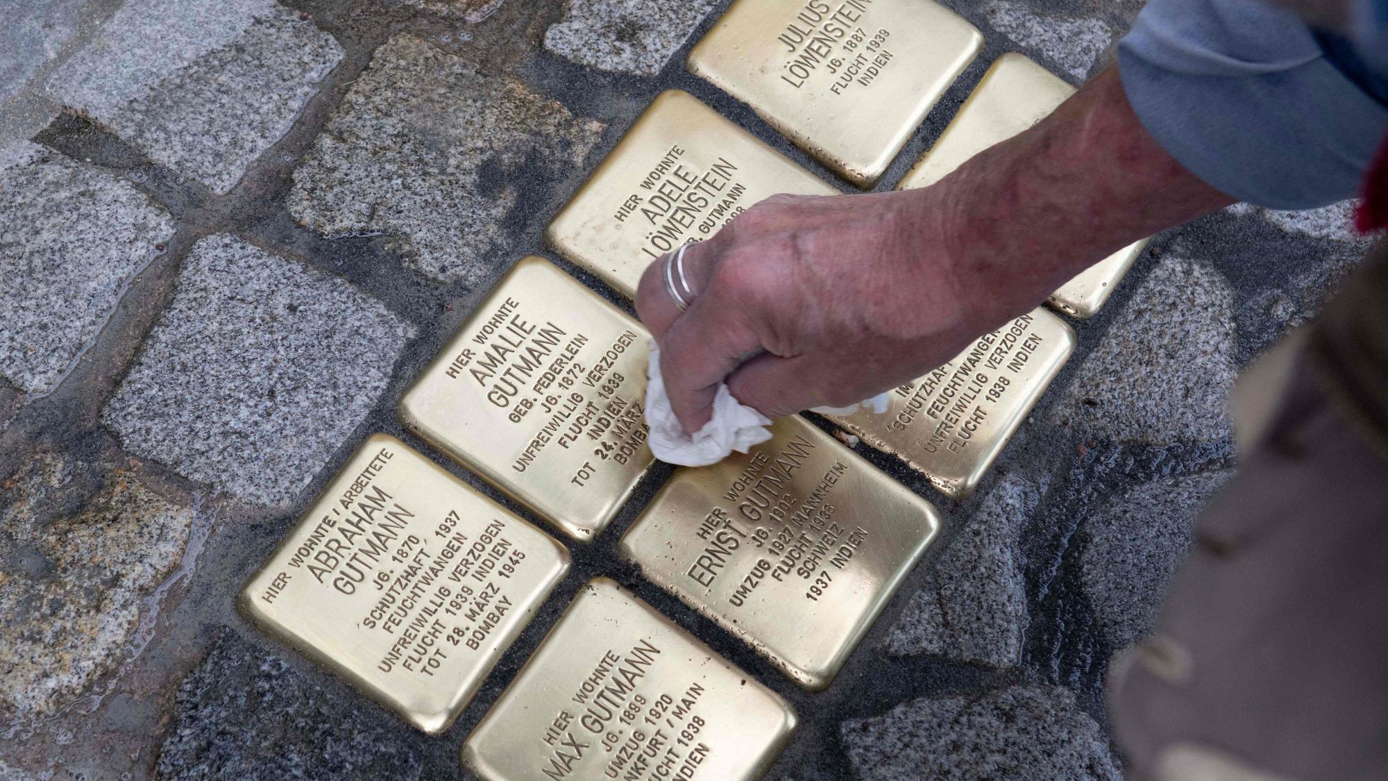 Stolpersteine von 8 jüdischen Menschen werden geputzt.