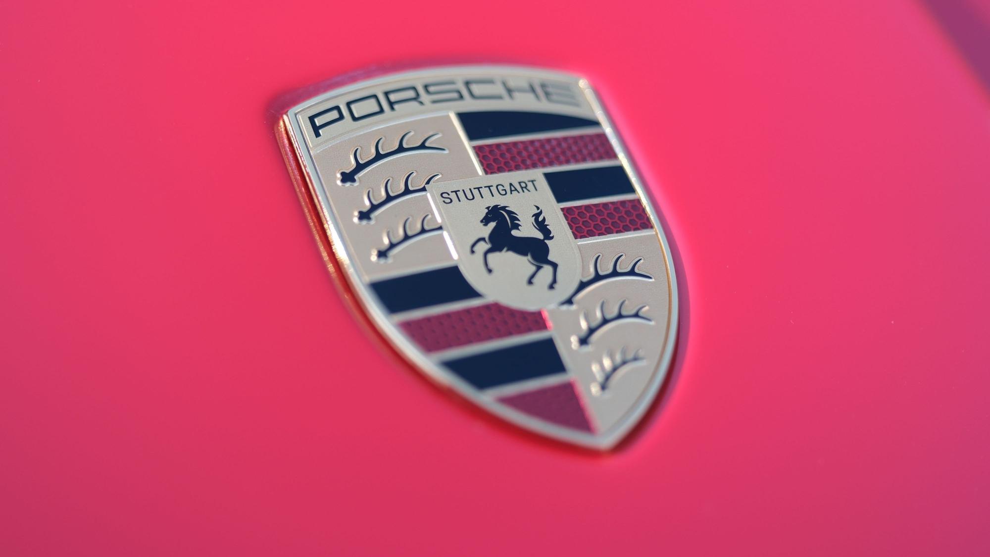 Der Schriftzug des Stuttgarter Sportwagenherstellers Porsche auf der Motorhaube eines roten Porsche-Sportwagens.