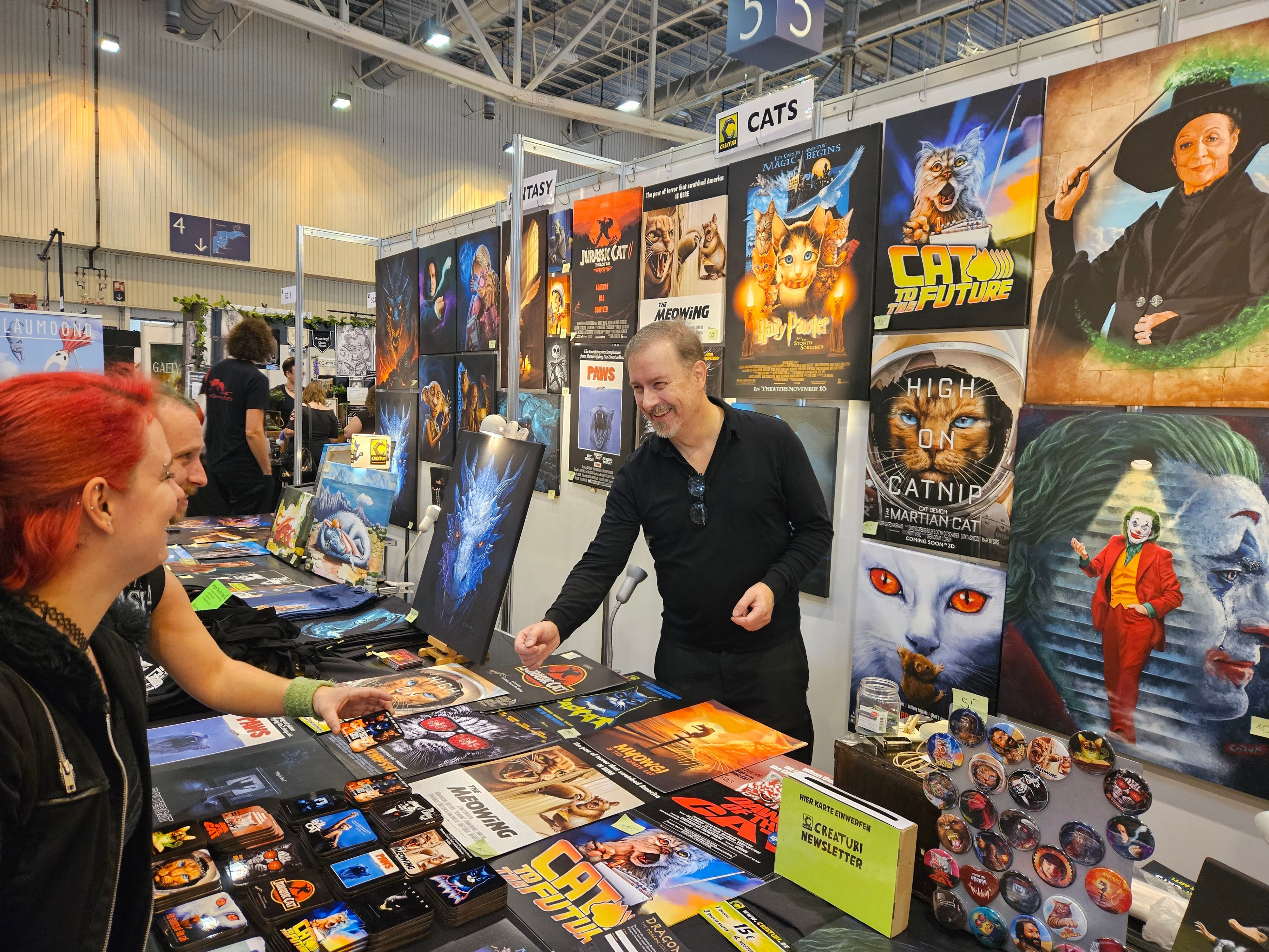 Ein Man steht hinter eine  Tresen mit Büchern auf der Spielemesse in Essen.