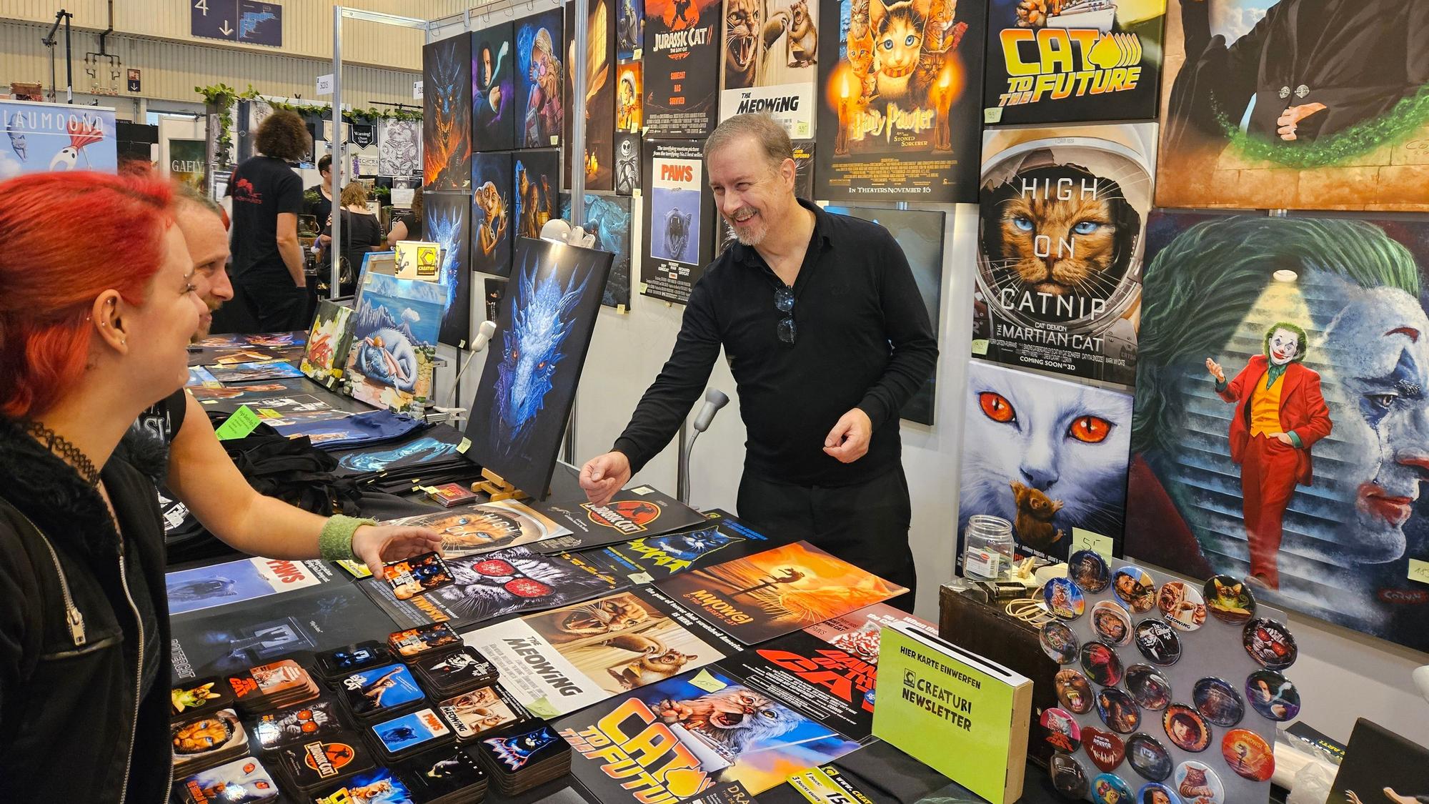 Ein Man steht hinter eine Tresen mit Büchern auf der Spielemesse in Essen.