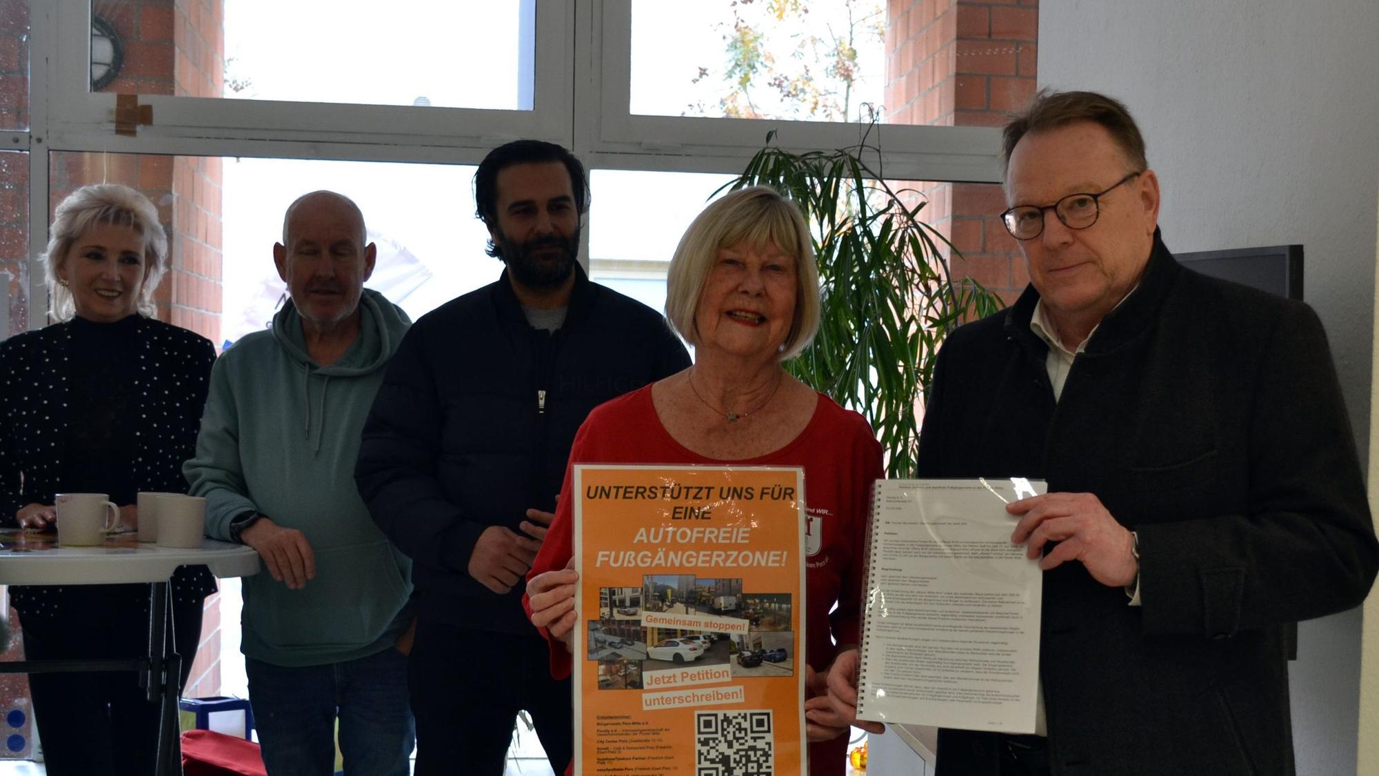 Anita Mirche (2.v.r.) überreicht OB Torsten Burmester (r.) im Beisein von weiteren Initiatoren die Unterschriftenlisten der Petition für eine autofreie Fußgängerzone in der Porzer Innenstadt.