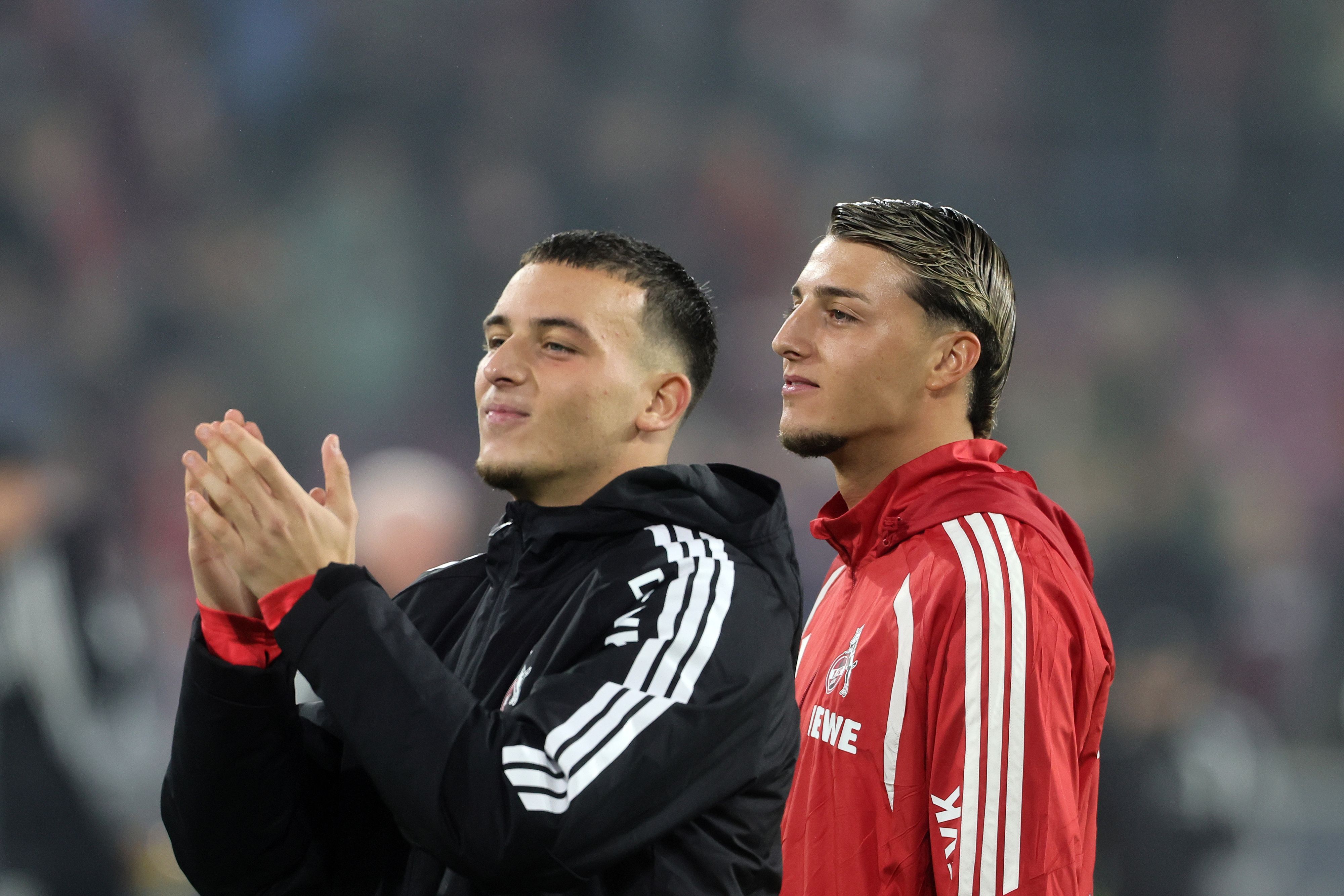 Said und Malek El Mala vom 1. FC Köln feiern nach Spielende mit den Kölner Fans.