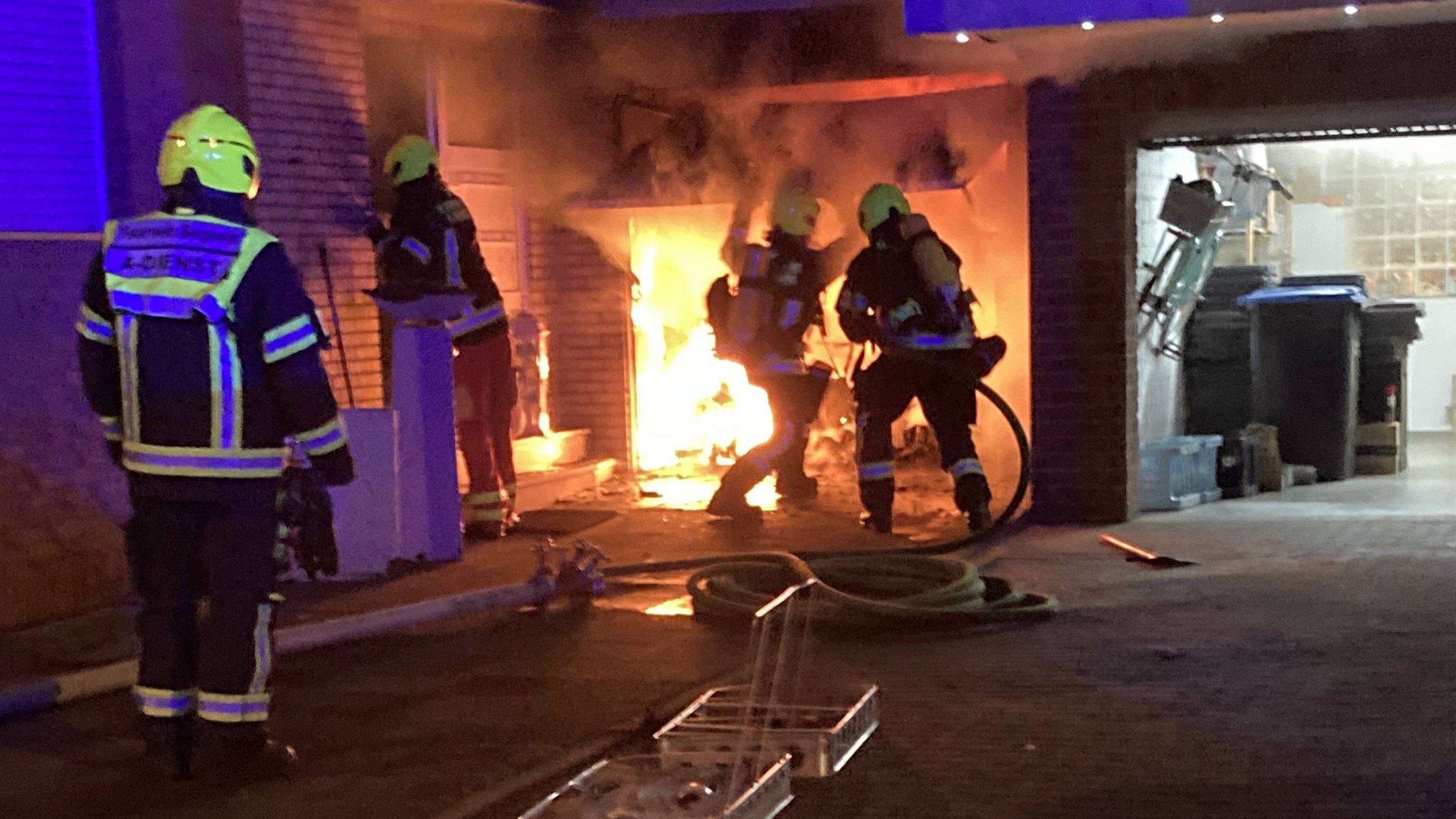 Feuerwehrleute löschen einen Garagenbrand.